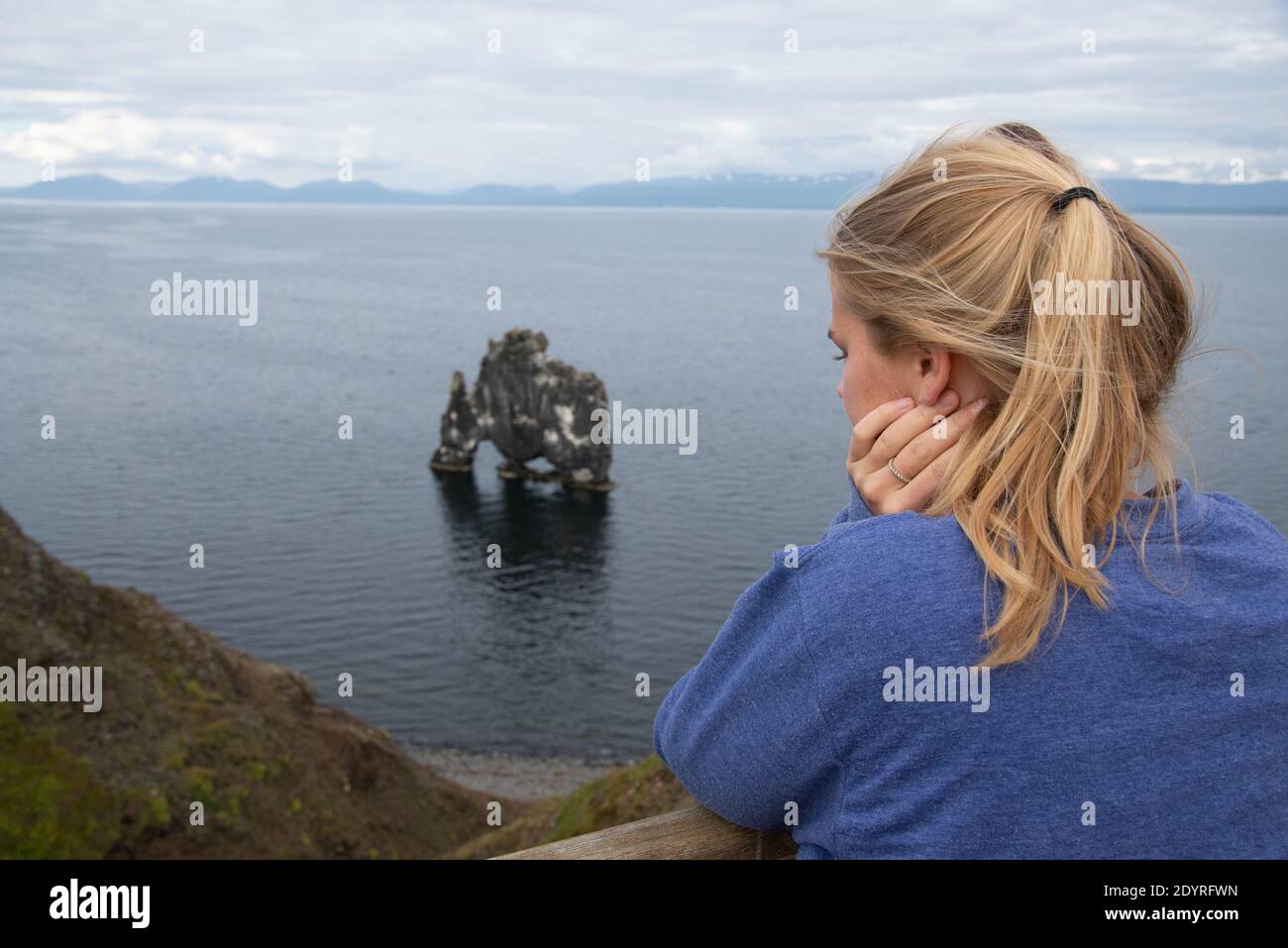 tourists looking at rocks t se at Hvitserkur in Iceland Stock Photo