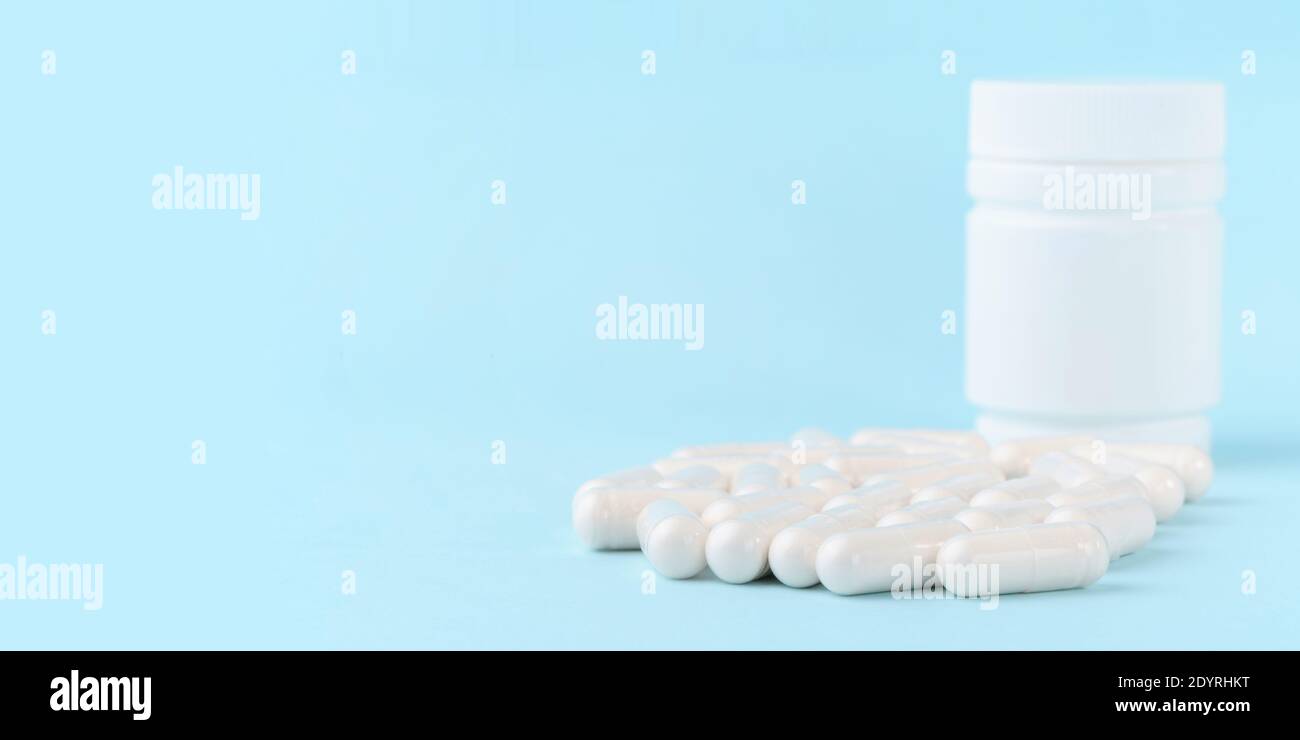 Medical capsules of glucosamine chondroitin, amino acids, maltodextrin on blue surface. Pharmaceutical supplements. Stock Photo