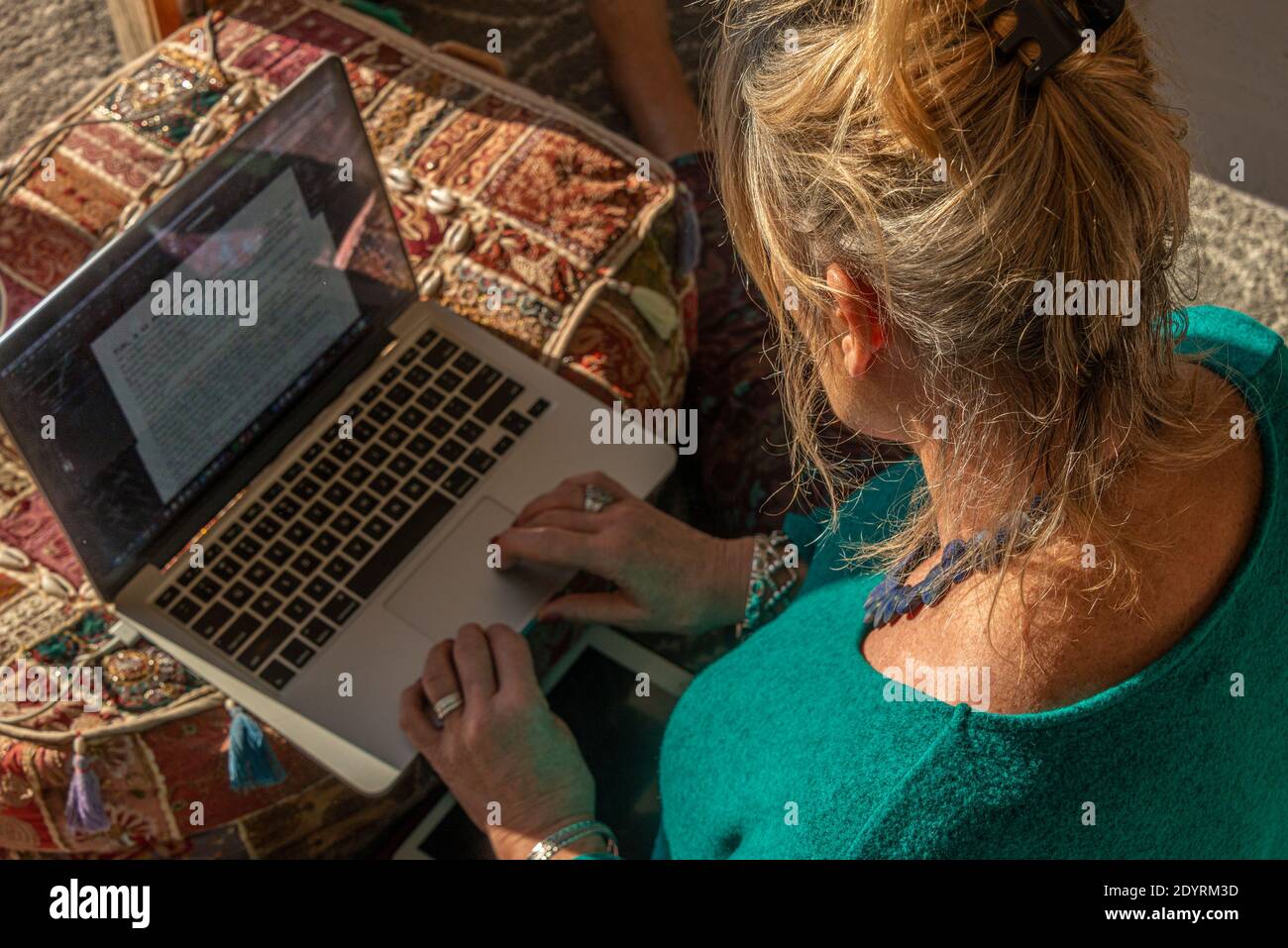 mixed race young woman typing on computer keyboard at table with