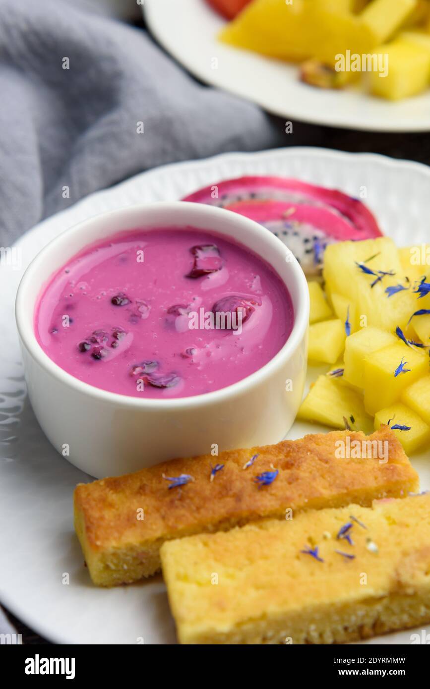 Mango bread with plant-based yogurt and fresh fruits, bright colors, colourful meal, 45 degree angle, close-up Stock Photo