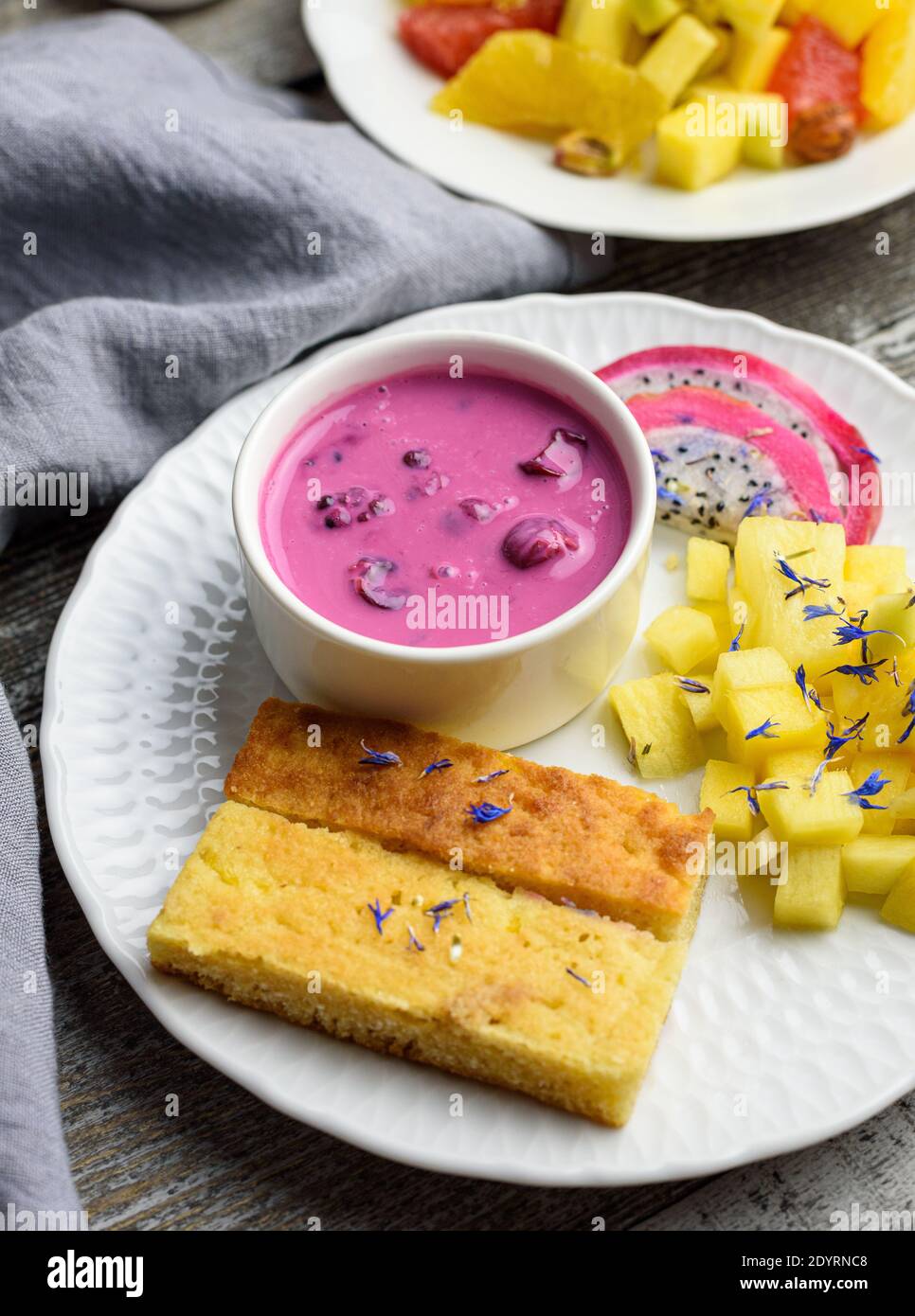 Mango bread with plant-based yogurt and fresh fruits, bright colors, colourful meal, 45 degree angle Stock Photo