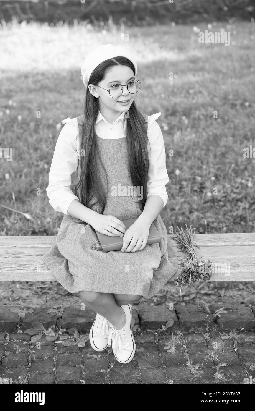 Define your style. Small child sit on bench outdoors. Little girl wear