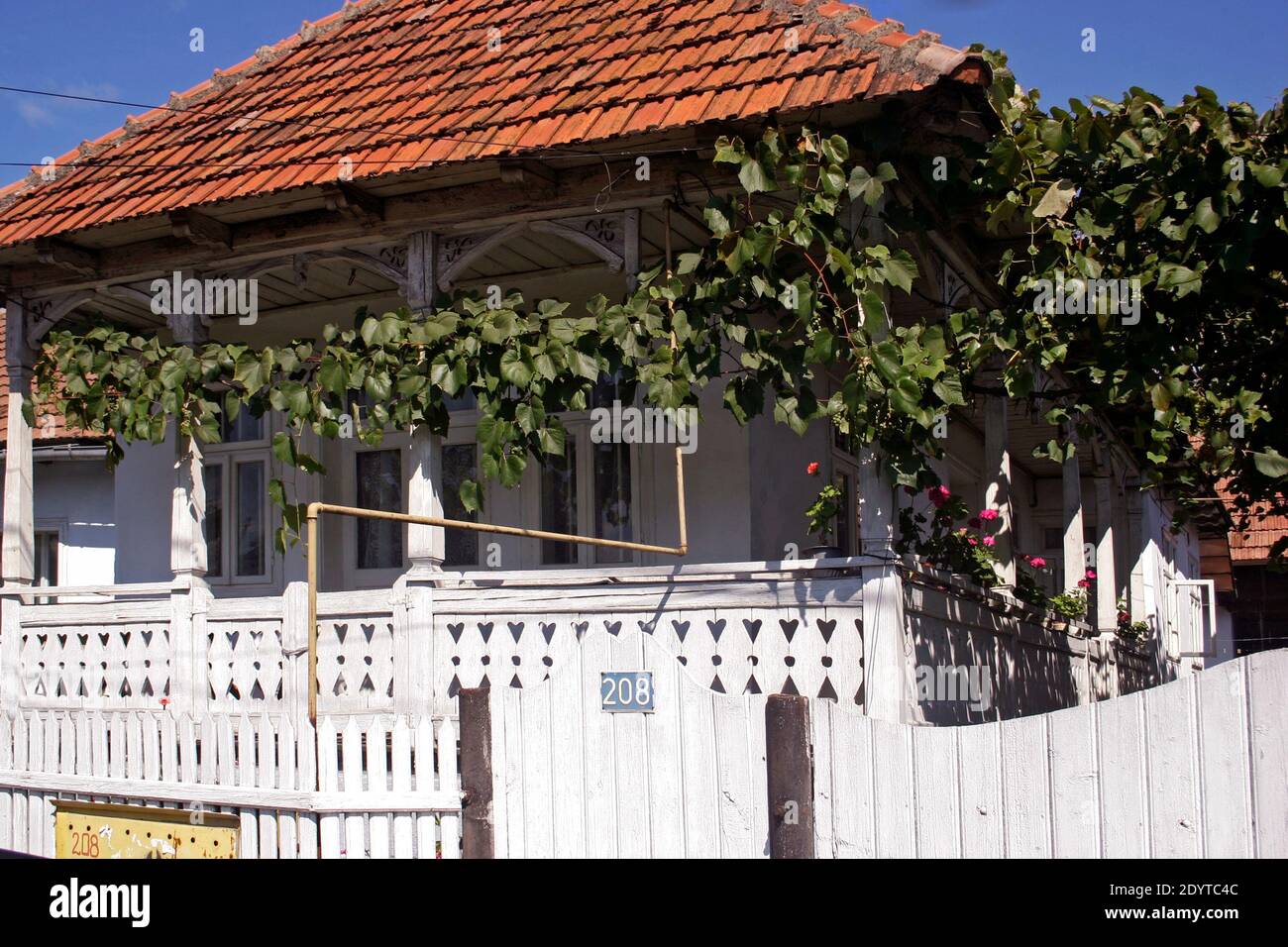 Bacau County, Romania. Old traditional house with wrap-around sculpted wooden porch. Stock Photo