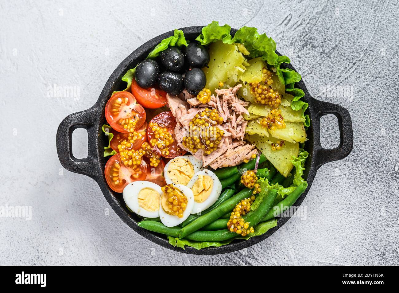 Gourmet nicoise salad with vegetables, eggs, tuna and anchovies in a