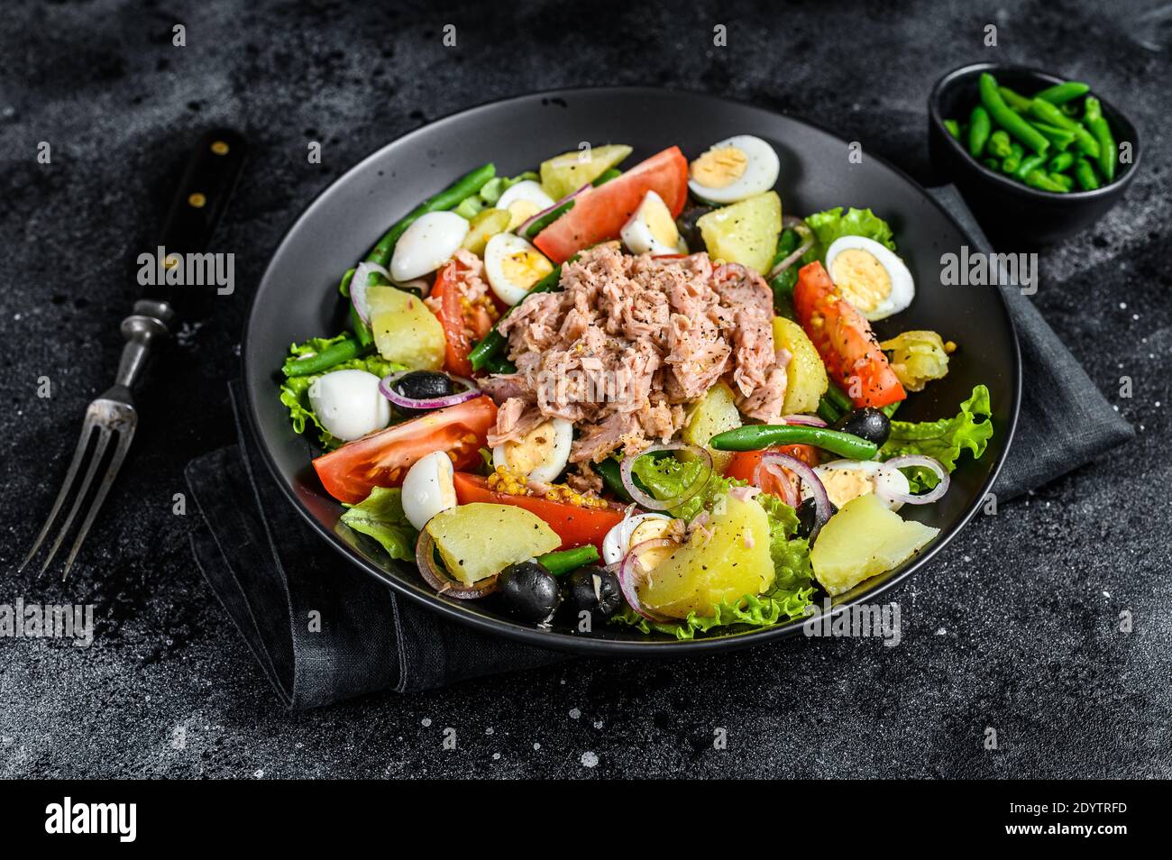 Tuna salad nicoise with vegetables, eggs and anchovies in a plate