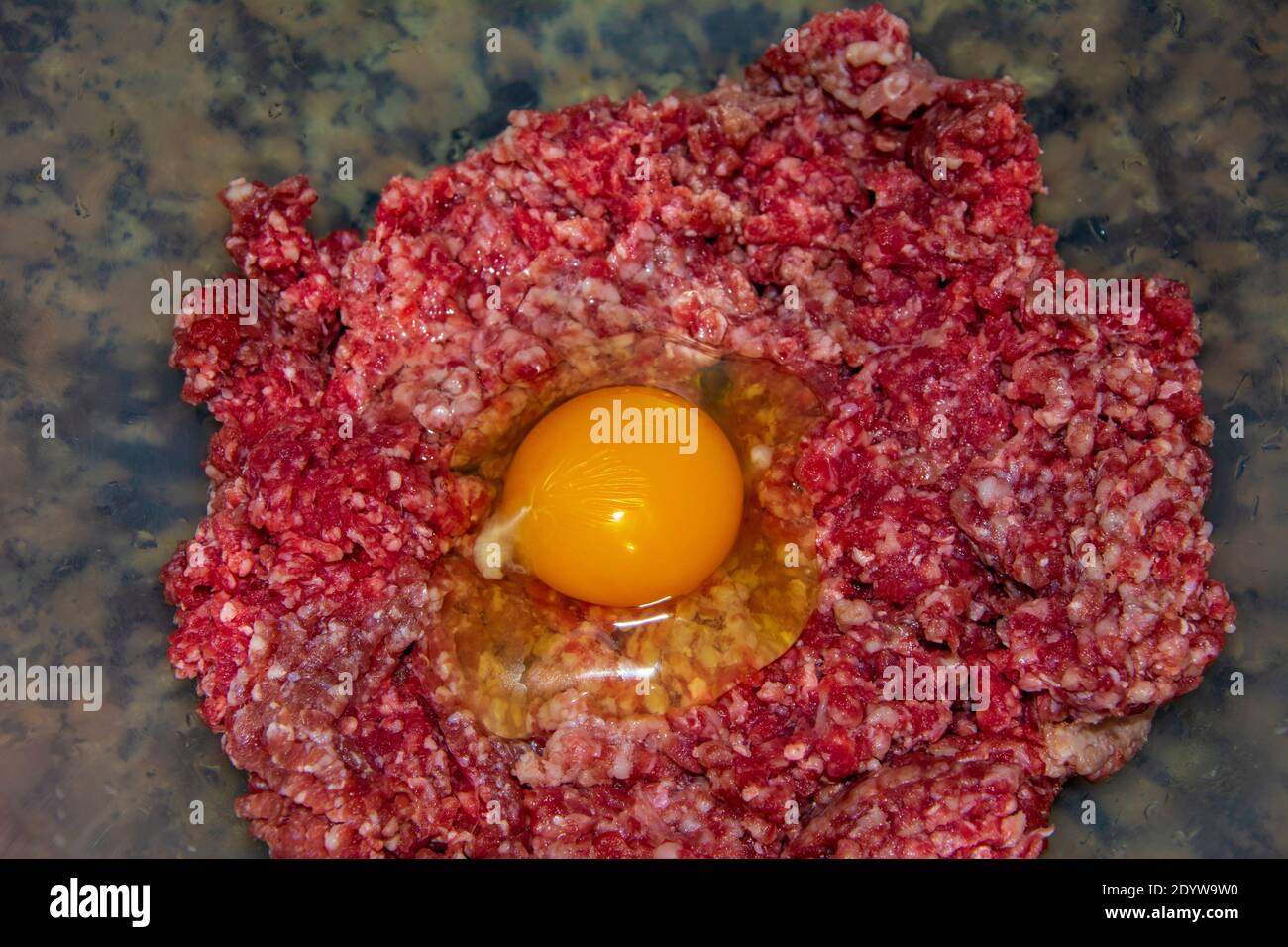 Egg on raw ground beef in close-up Stock Photo