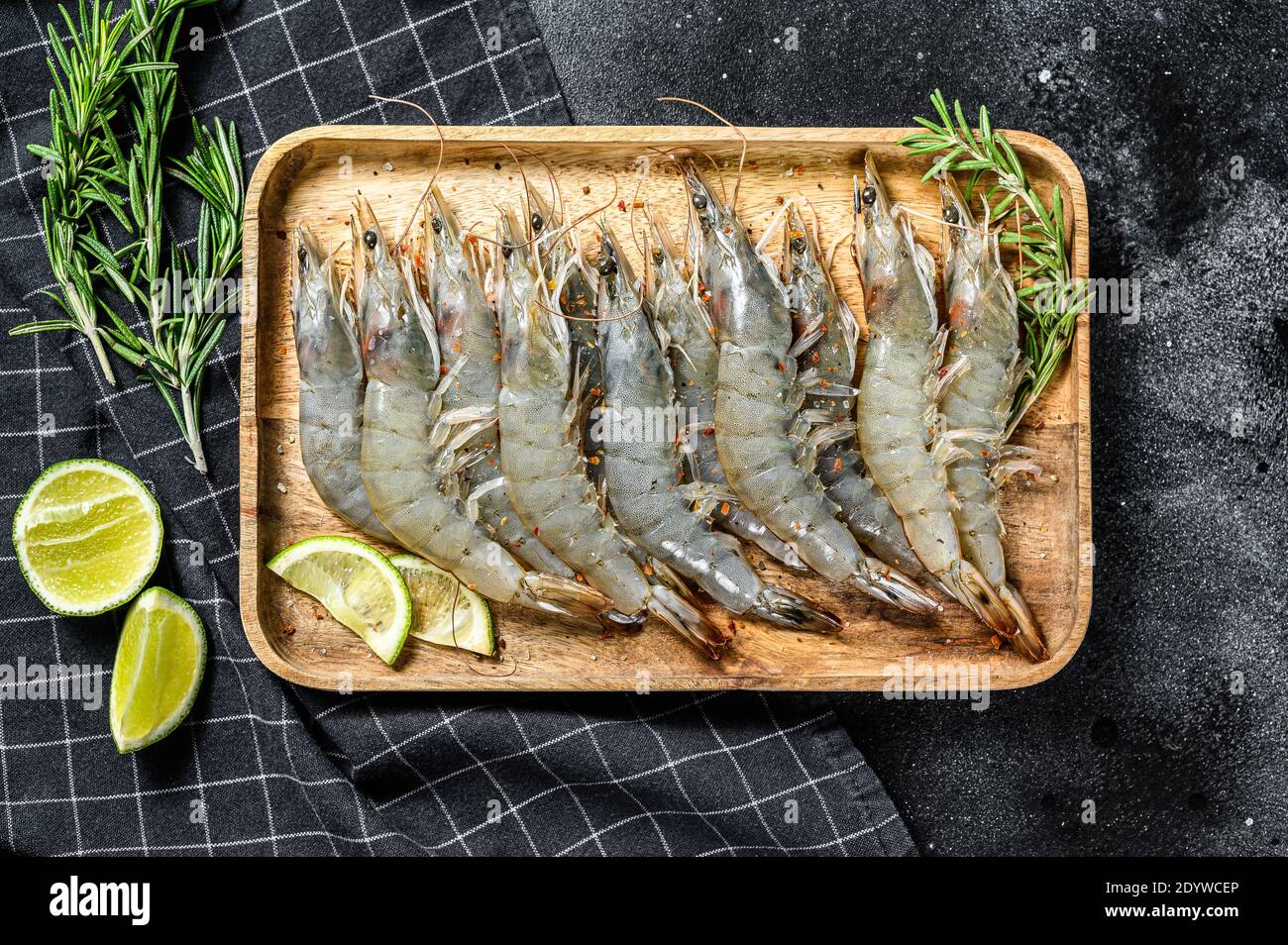 Whole fresh raw langoustine prawns, shrimps on a wooden tray. Black background. Top view Stock Photo