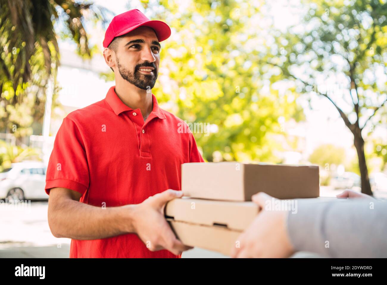 Delivery man carrying packages while making home delivery Stock Photo