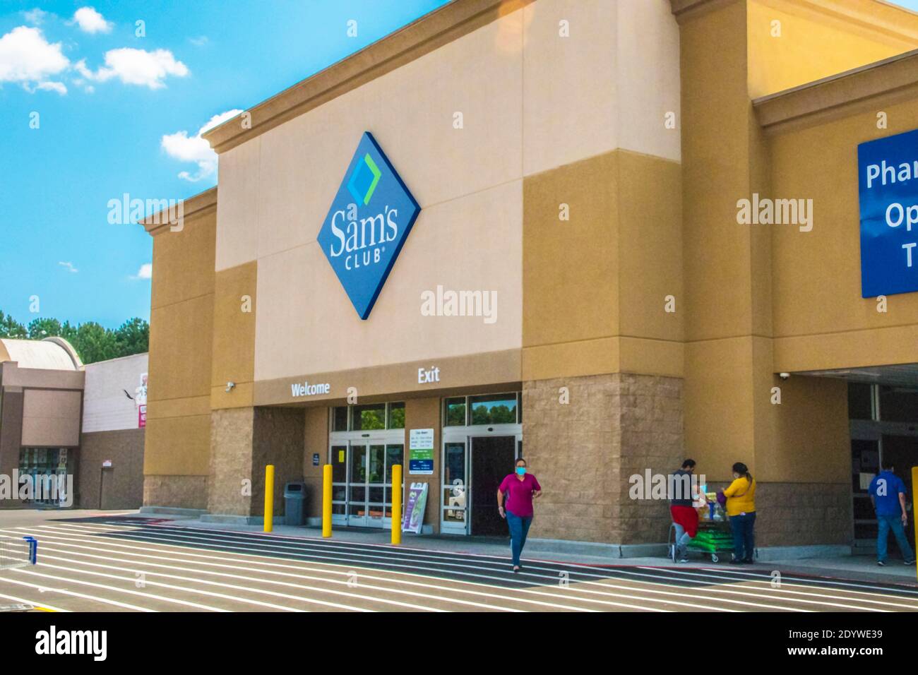 Gwinnett, County USA - 05 31 20: Sams Club building sign and  lady with a face mask on Stock Photo