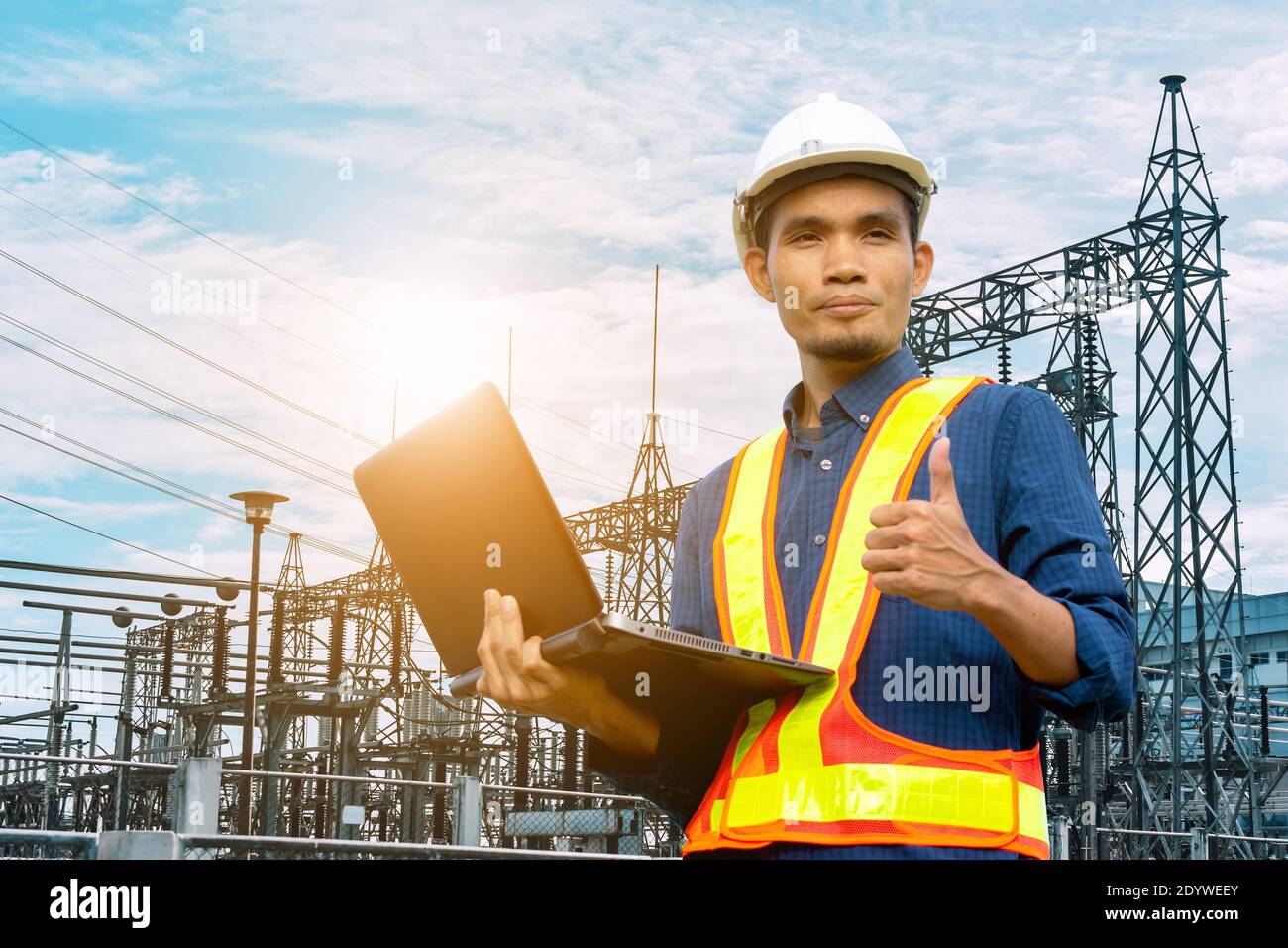 Engineer holding computer laptop electric factory system background Stock Photo