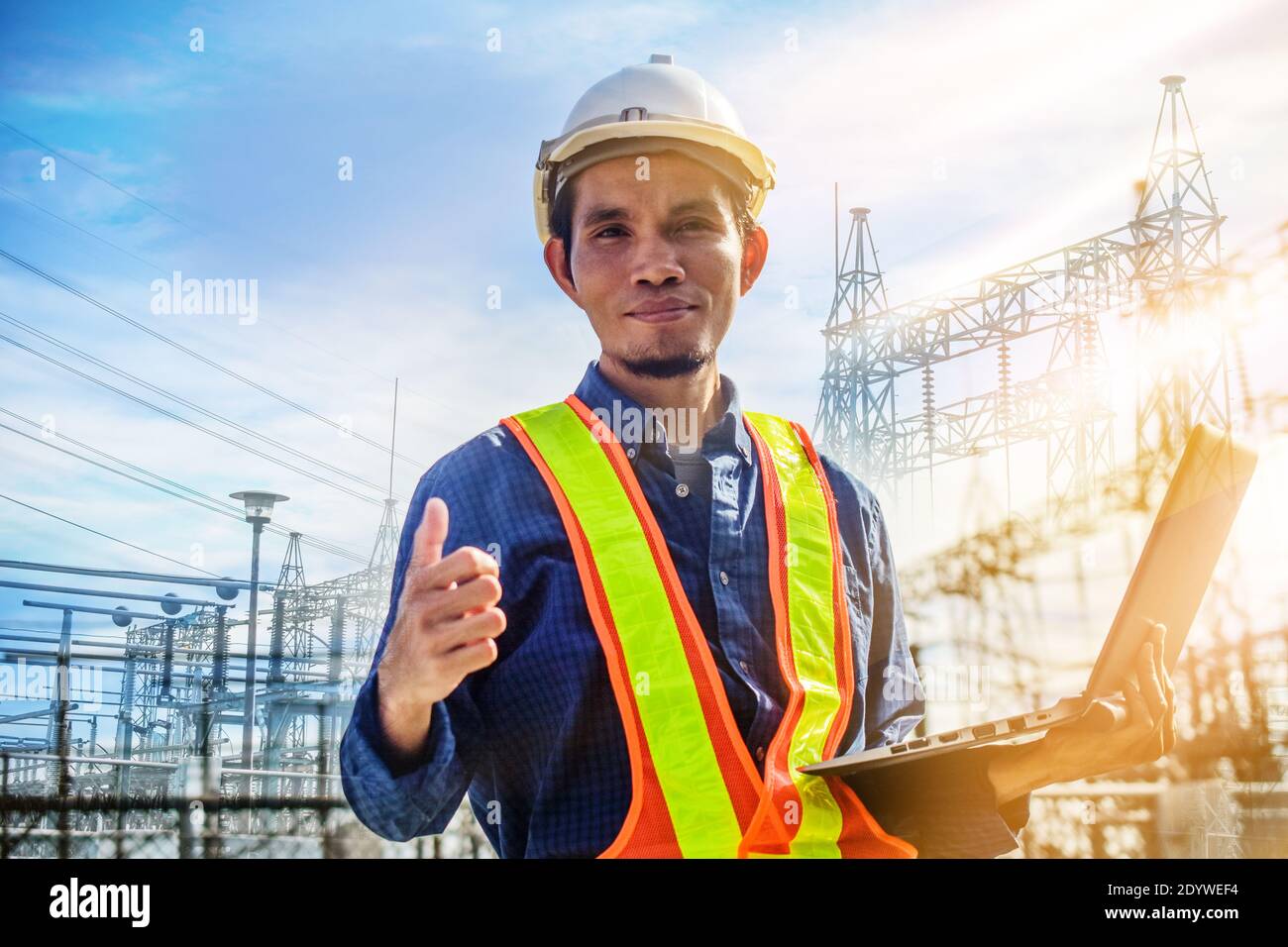 Engineer holding computer laptop electric factory system background Stock Photo