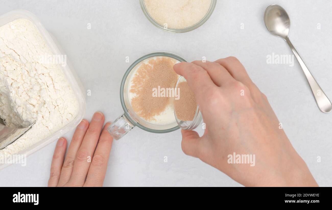 Dissolving dry yeast in warm milk. Step by step flat bread recipe, baking process. Close up view
