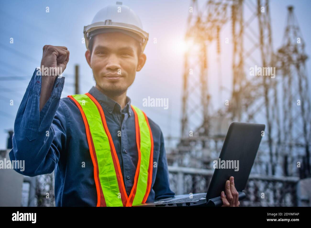 Engineer holding computer notebook high voltage power plant background Stock Photo