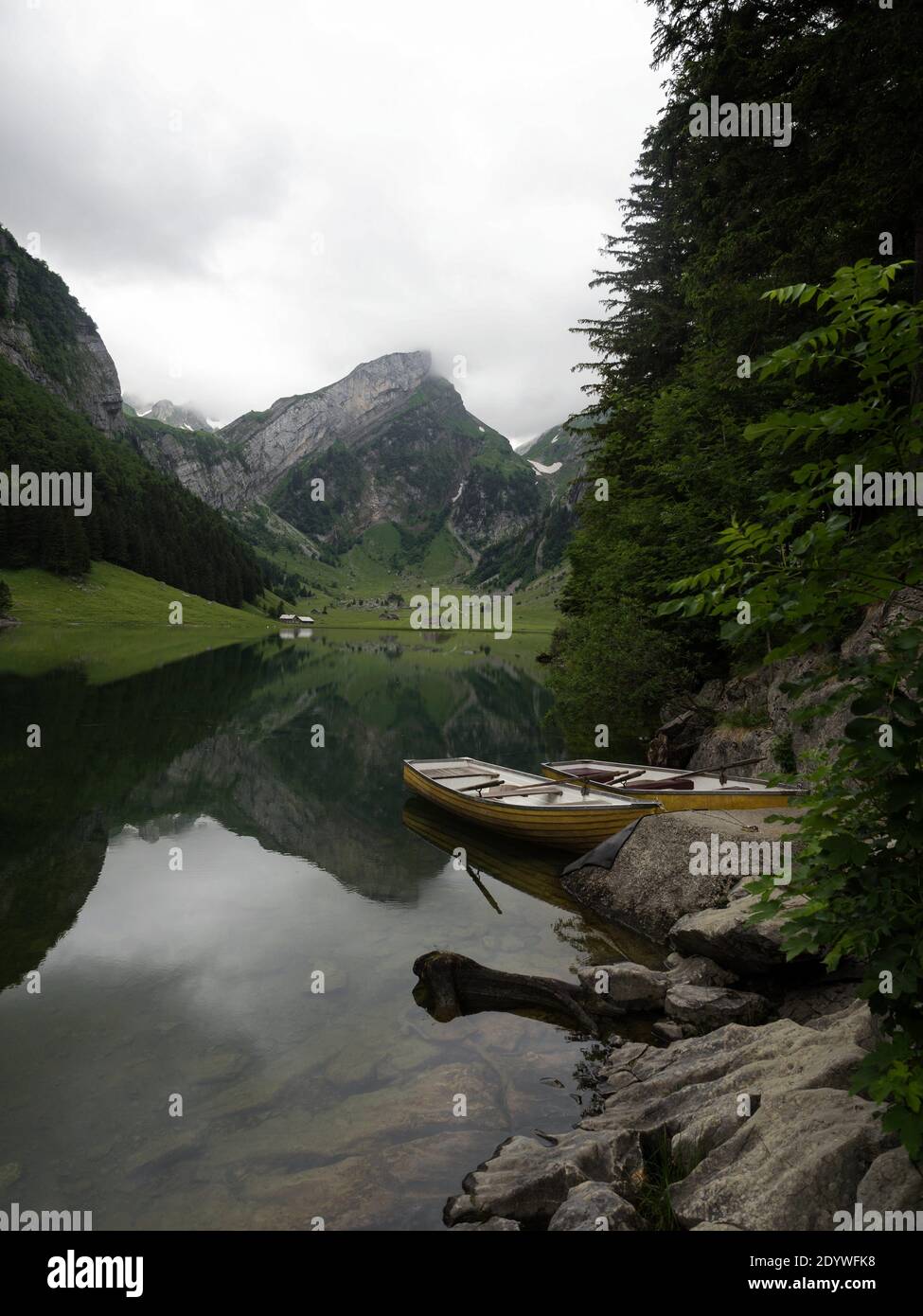Yellow rowing paddle boat on alpine lake Seealpsee in Alpstein alps ...