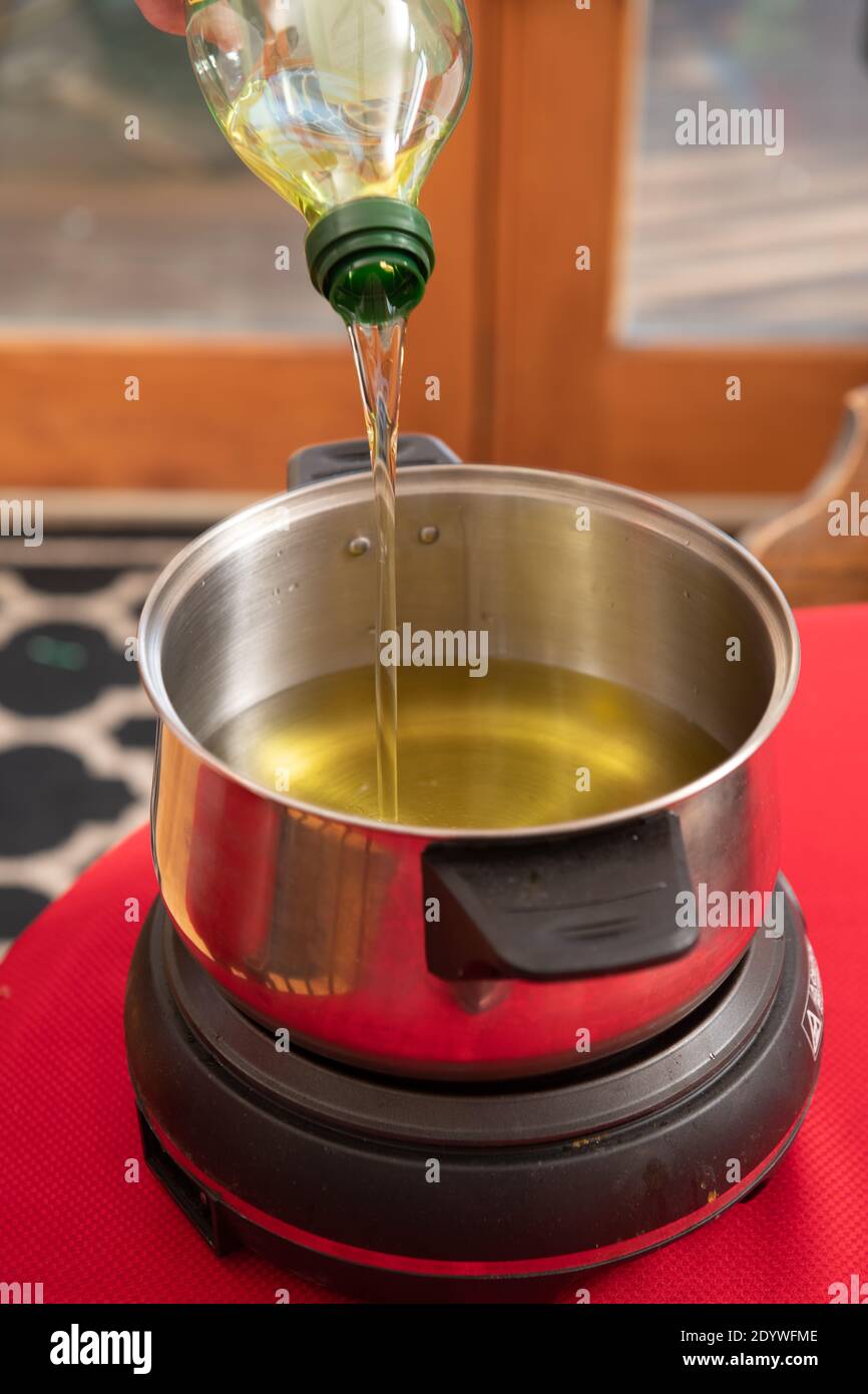 Oil being poured into pot for cooking meat for fondue Stock Photo Alamy