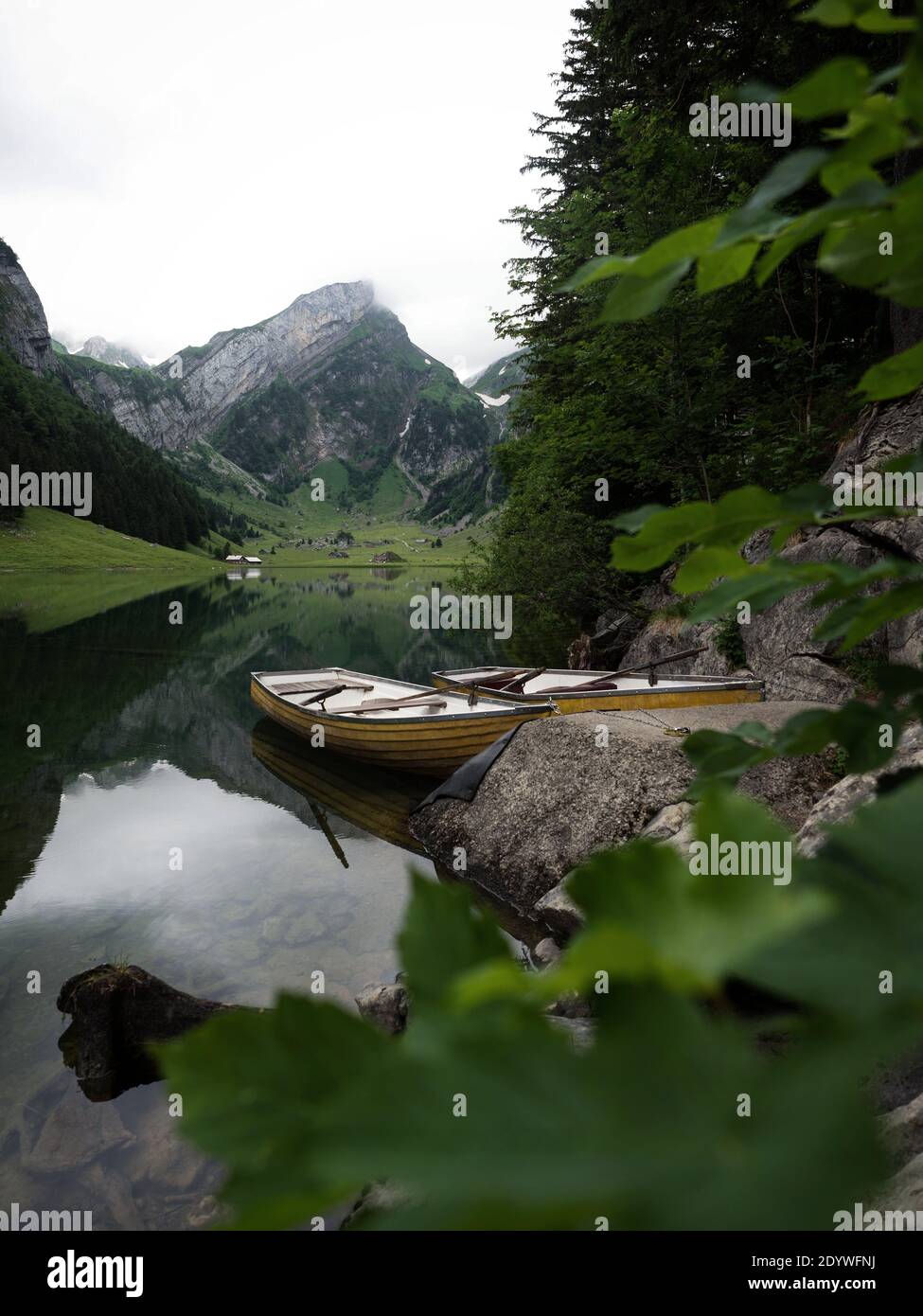 Yellow rowing paddle boat on alpine lake Seealpsee in Alpstein alps ...