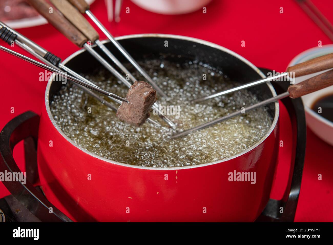 Steak meat cooking in oil at home being done in fondue style. Stock Photo