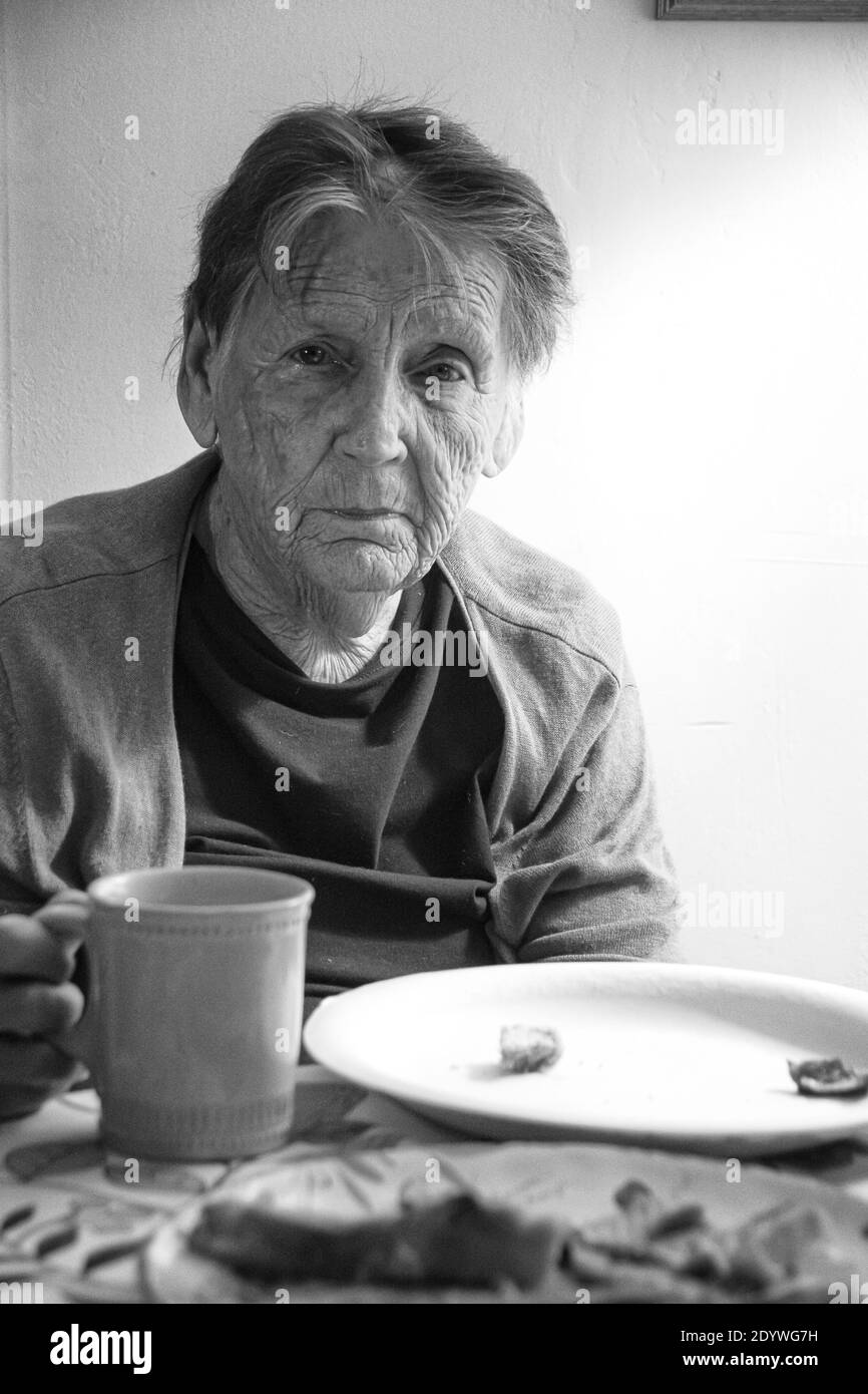 An 84 year old woman suffering from depression, having a cup of coffee. Stock Photo