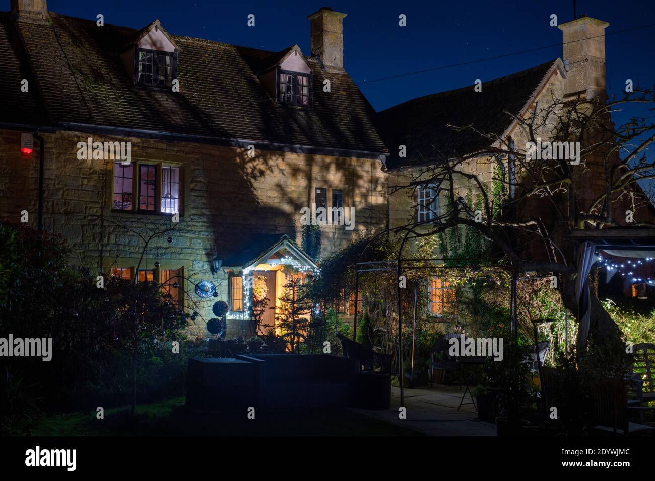 Christmas decorations and lights outside a cotswold stone cottage at