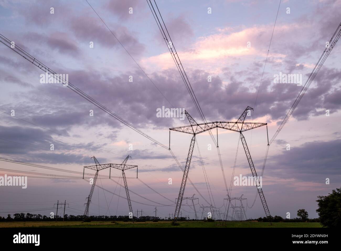 High-voltage power lines at sunset. High voltage electric transmission tower.  Stock Photo