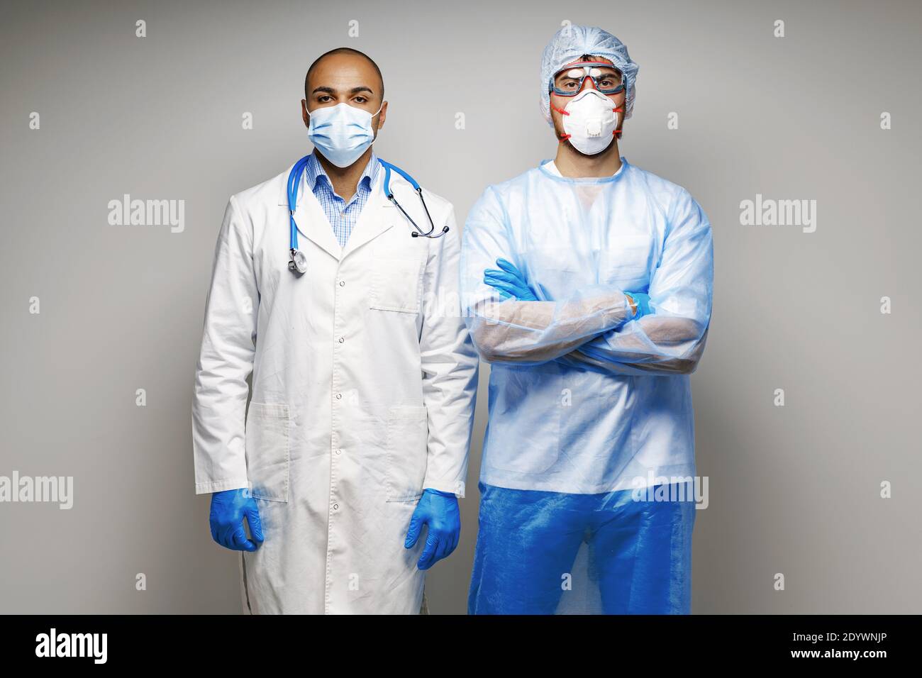 Doctors In Uniform Male doctors in medical uniform wearing masks standing against grey ...