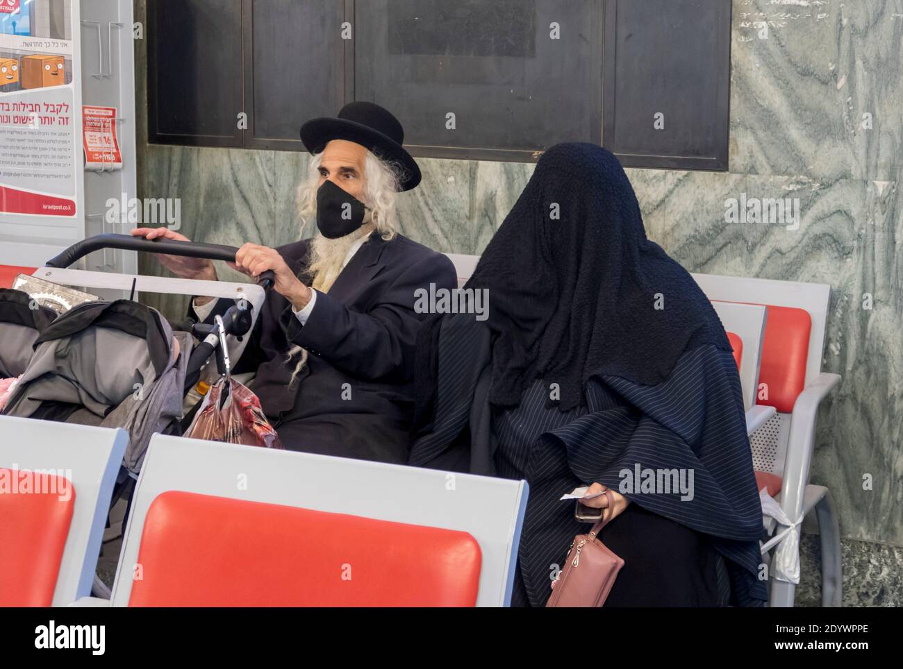 A couple of the so called Haredi Burqa Sect ( Jewish religious group, in which ultra-Orthodox Jewish women claim that modesty calls for a burqa-style covering of the entire body ) waiting for service in a post office in Jerusalem Israel. The Shalim, commonly known as the 'burqa cult,' is one of the most isolated and denigrated sects in Israel, even among the country's ultra-Orthodox population. Stock Photo