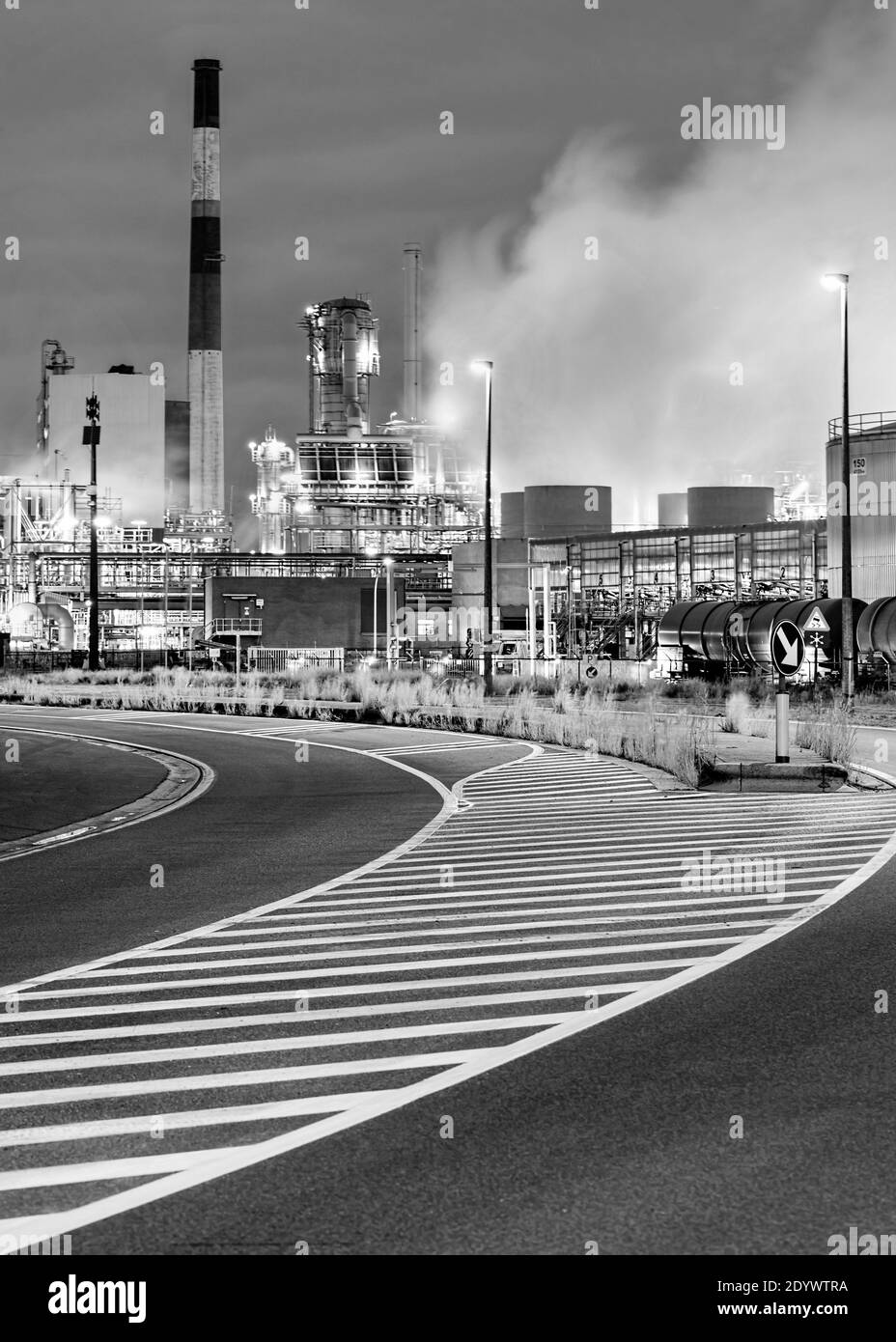 Twilight scene with road marks and petrochemical production plant on the background, Port of Antwerp, Belgium. Stock Photo