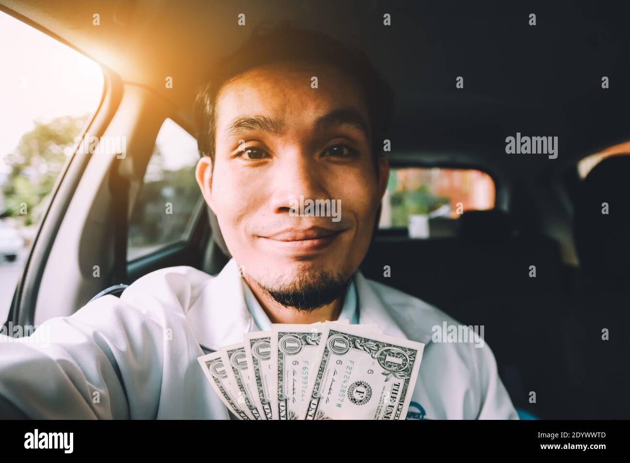 Man with us dollar for use in car,Money for everyday life Stock Photo