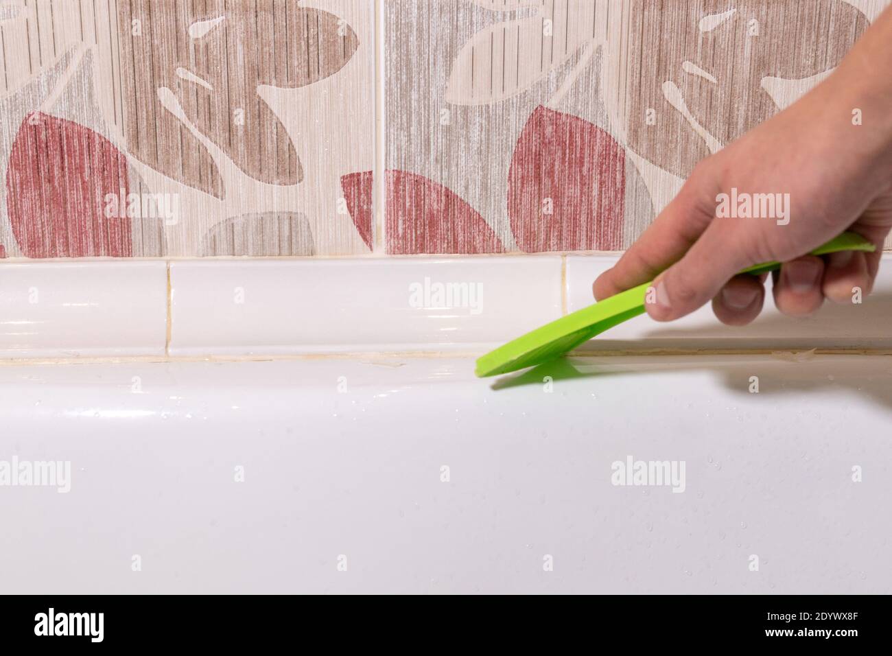 removing old dirty silicone from bathtub in a washroom Stock Photo Alamy