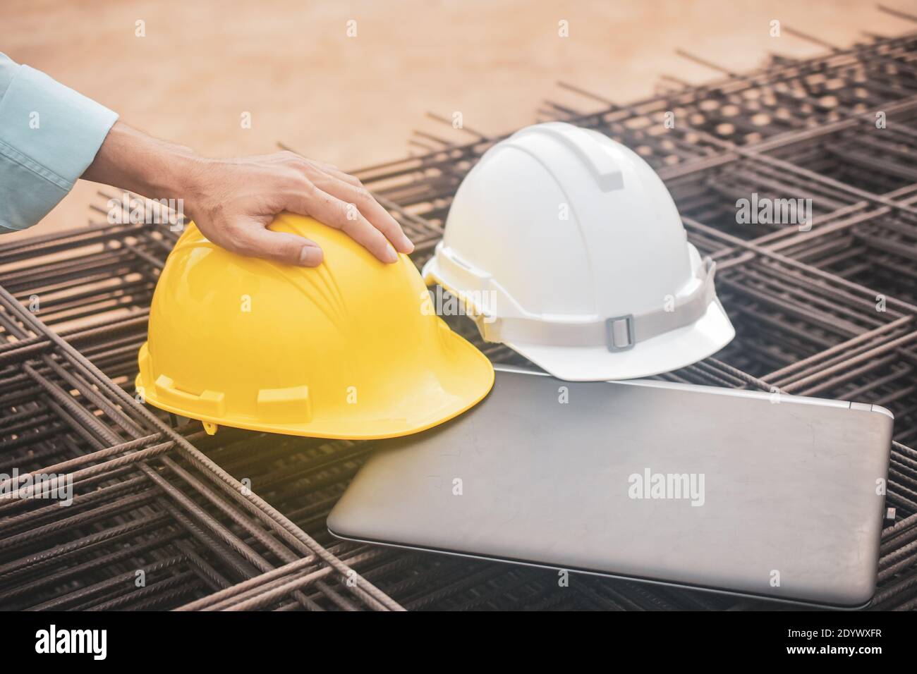 Close up hard hat on laptop at real estate construction site Stock Photo