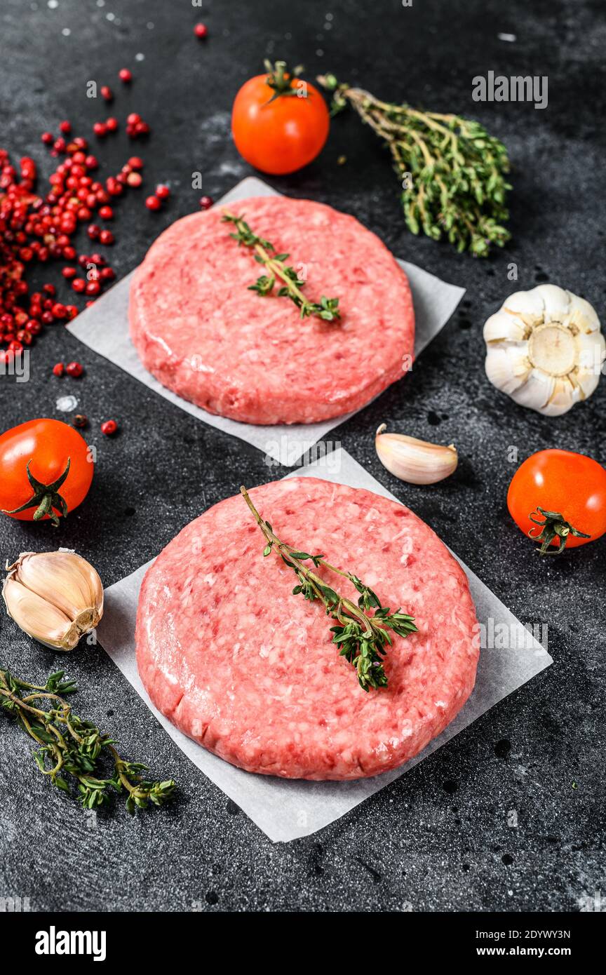 Raw mince meat cutlet, ground beef and pork. Burger patties. Black background. Top view Stock Photo
