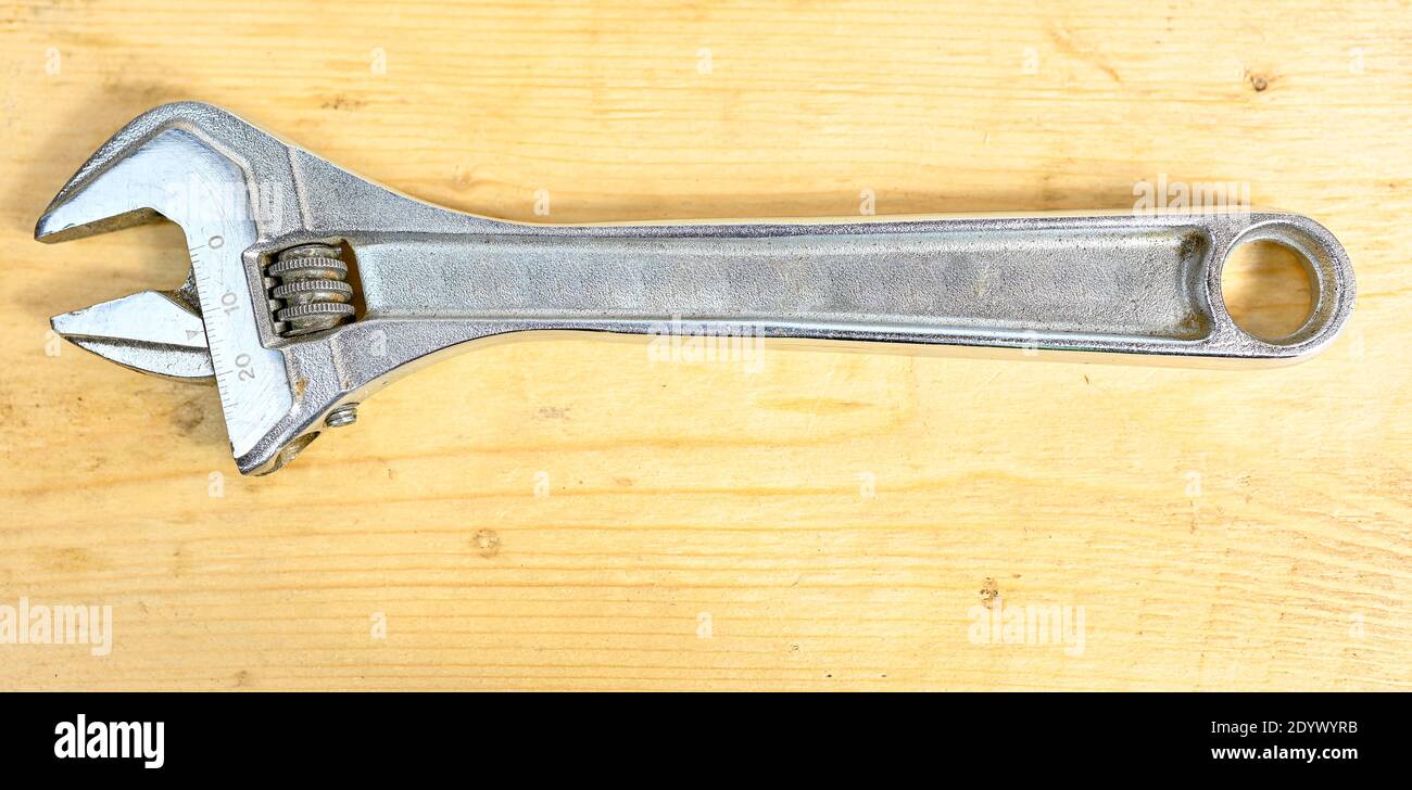 wrench lying on wooden bench in workshop Stock Photo