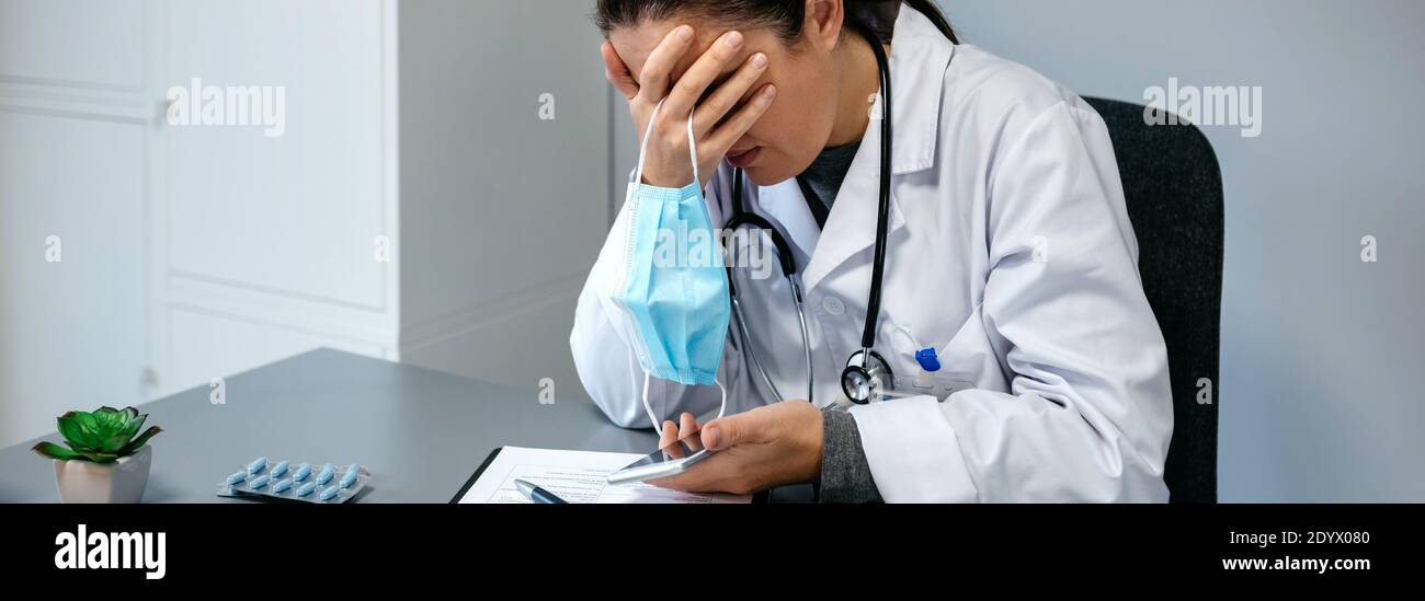 Worried female doctor with hands on face Stock Photo