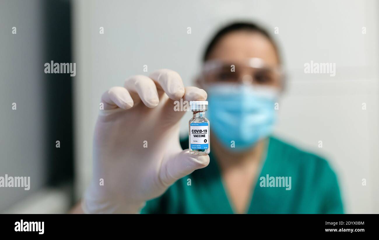 Female laboratory technician showing vial of coronavirus vaccine Stock Photo