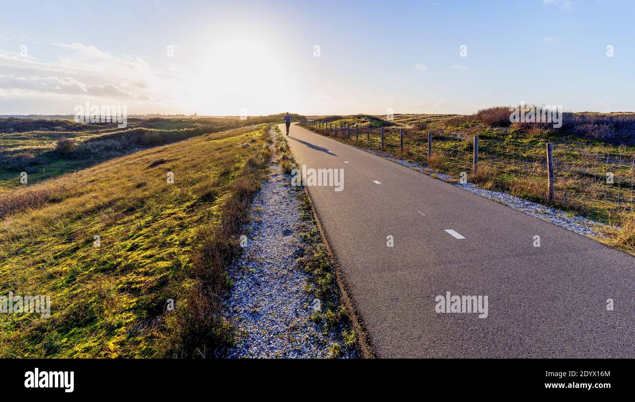 Tracker Landscape Image Bicycle track in dune landscape with runner on the horizon Stock Photo ...