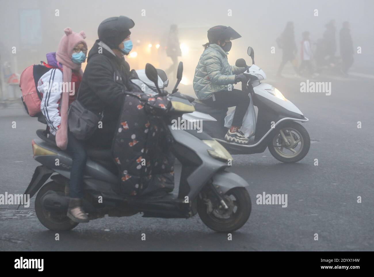 Vehicles, motors and pedestrians trek on the road as heavy fog impedes the traffic, Lianyungang city, east China’s Jiangsu province, 28 December 2020. Stock Photo