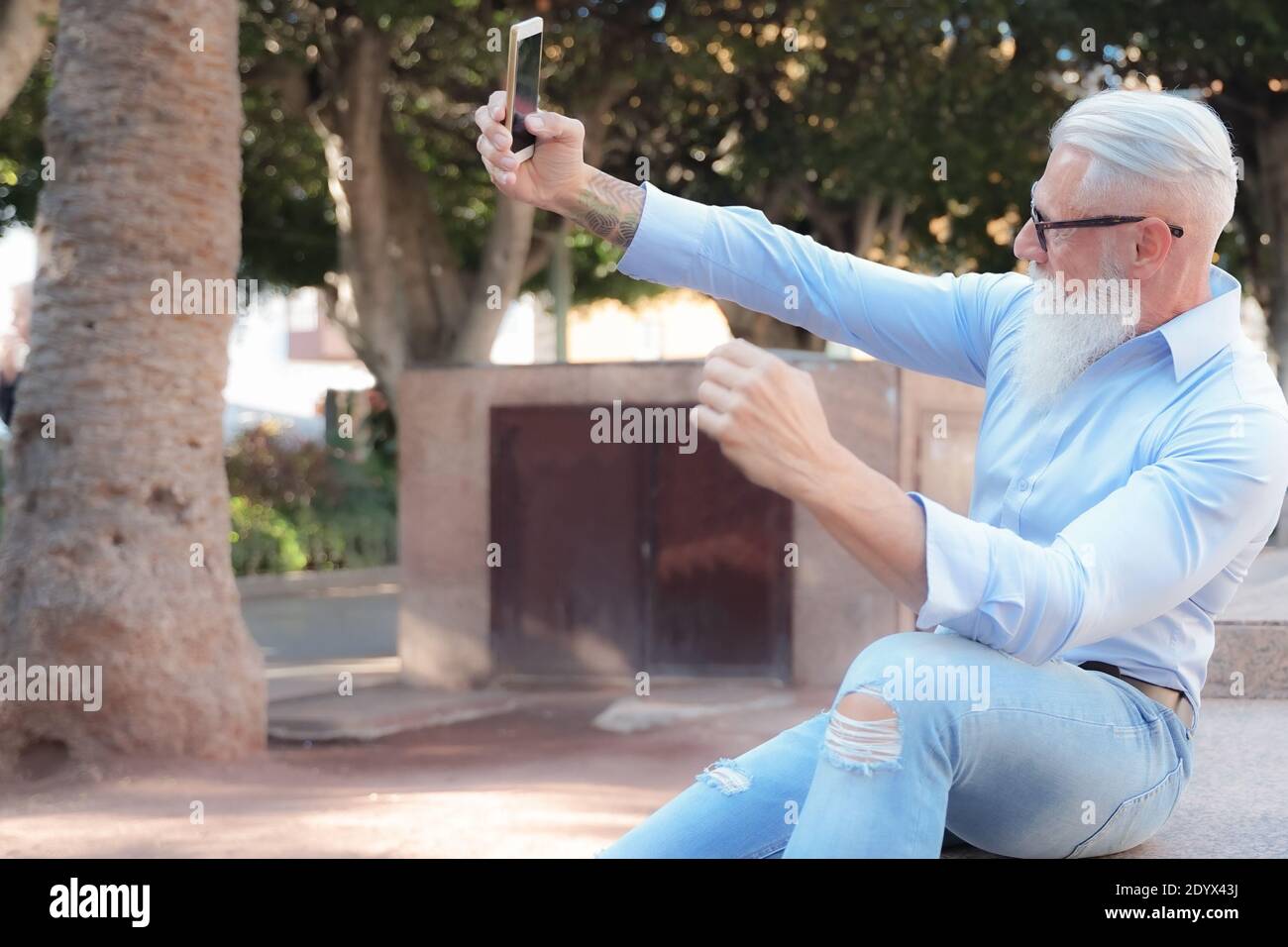 Old man making a selfie with an smartphone. pensioner and technology concept. Stock Photo