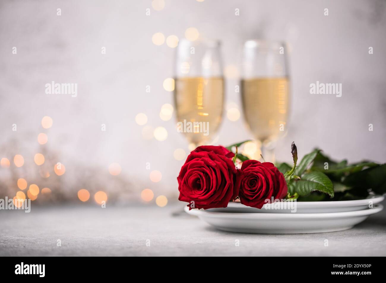 Valentines day table setting red roses and champagne glasses on ...