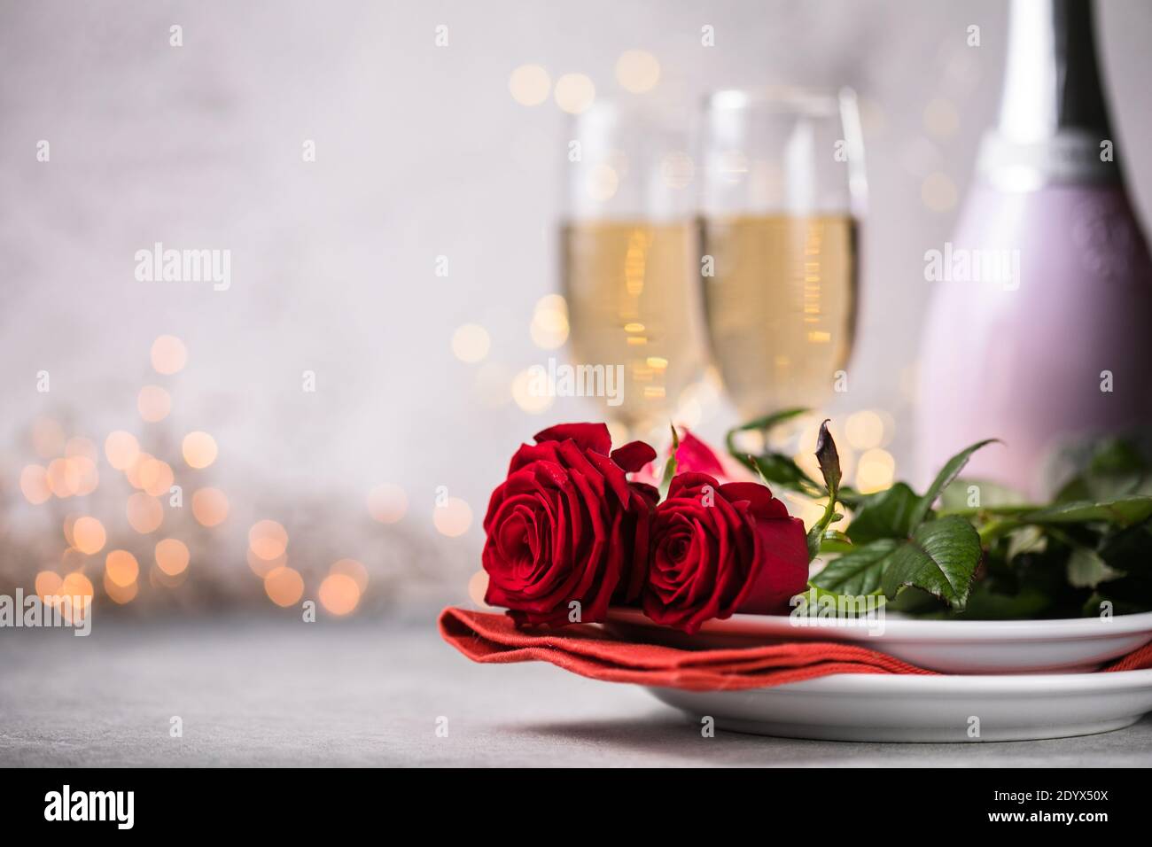 Valentines day table setting red roses and champagne glasses on ...
