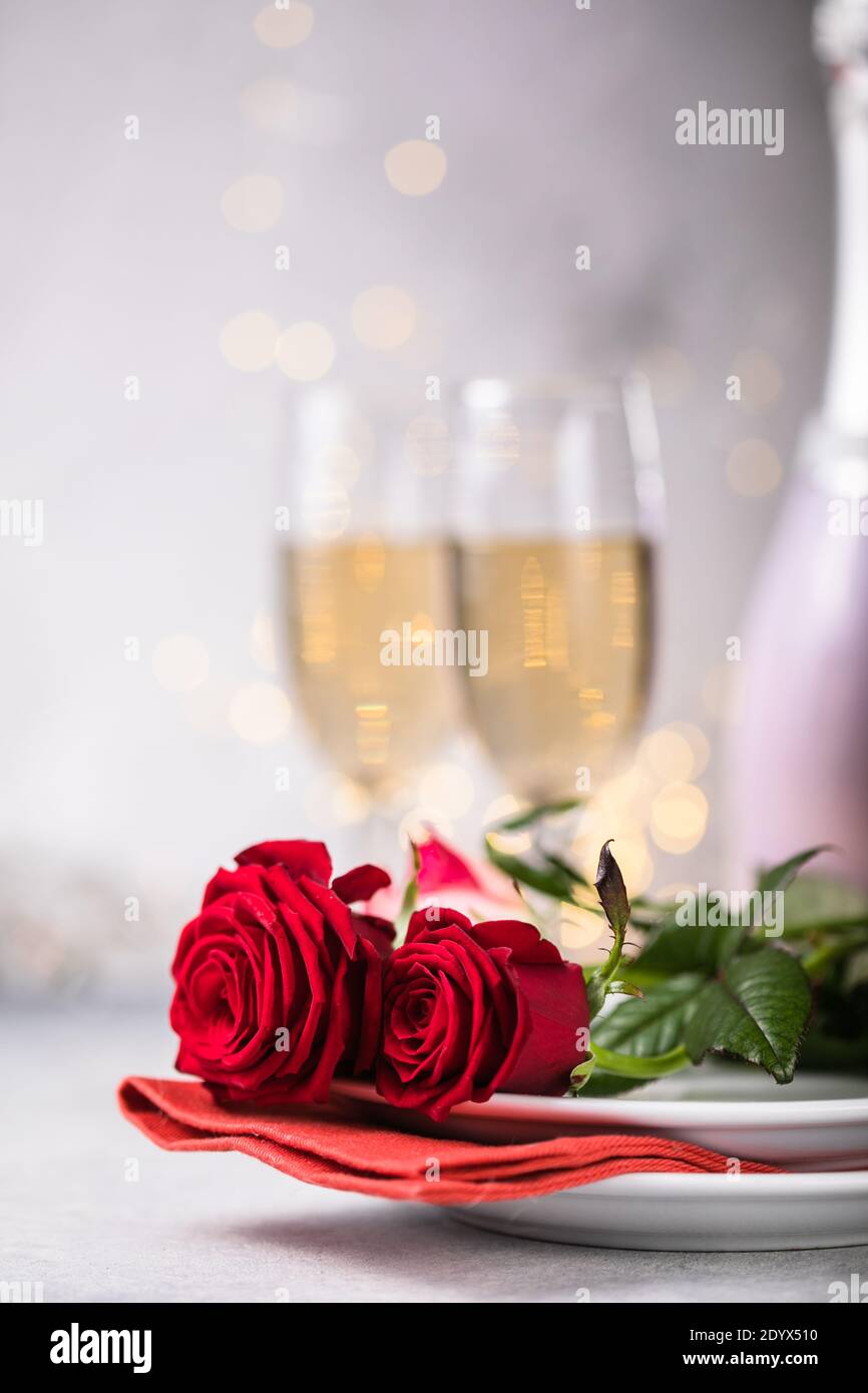 Valentines day table setting red roses and champagne glasses on ...