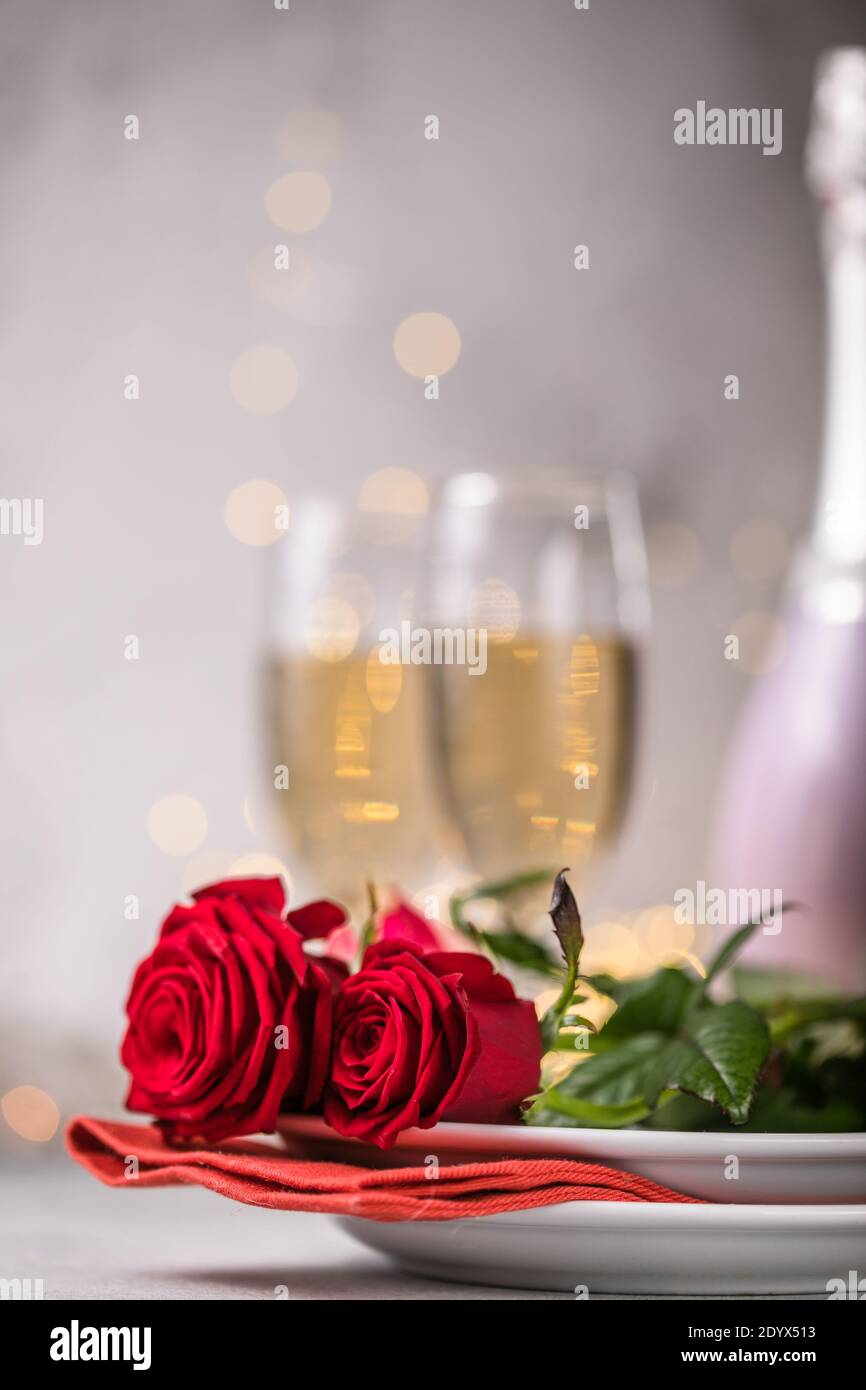 Valentines day table setting red roses and champagne glasses on ...