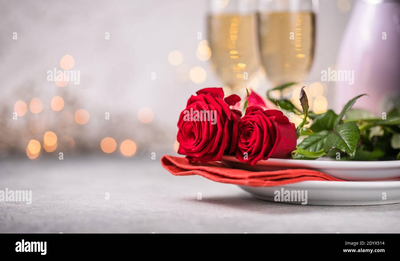 Valentines day table setting red roses and champagne glasses on ...