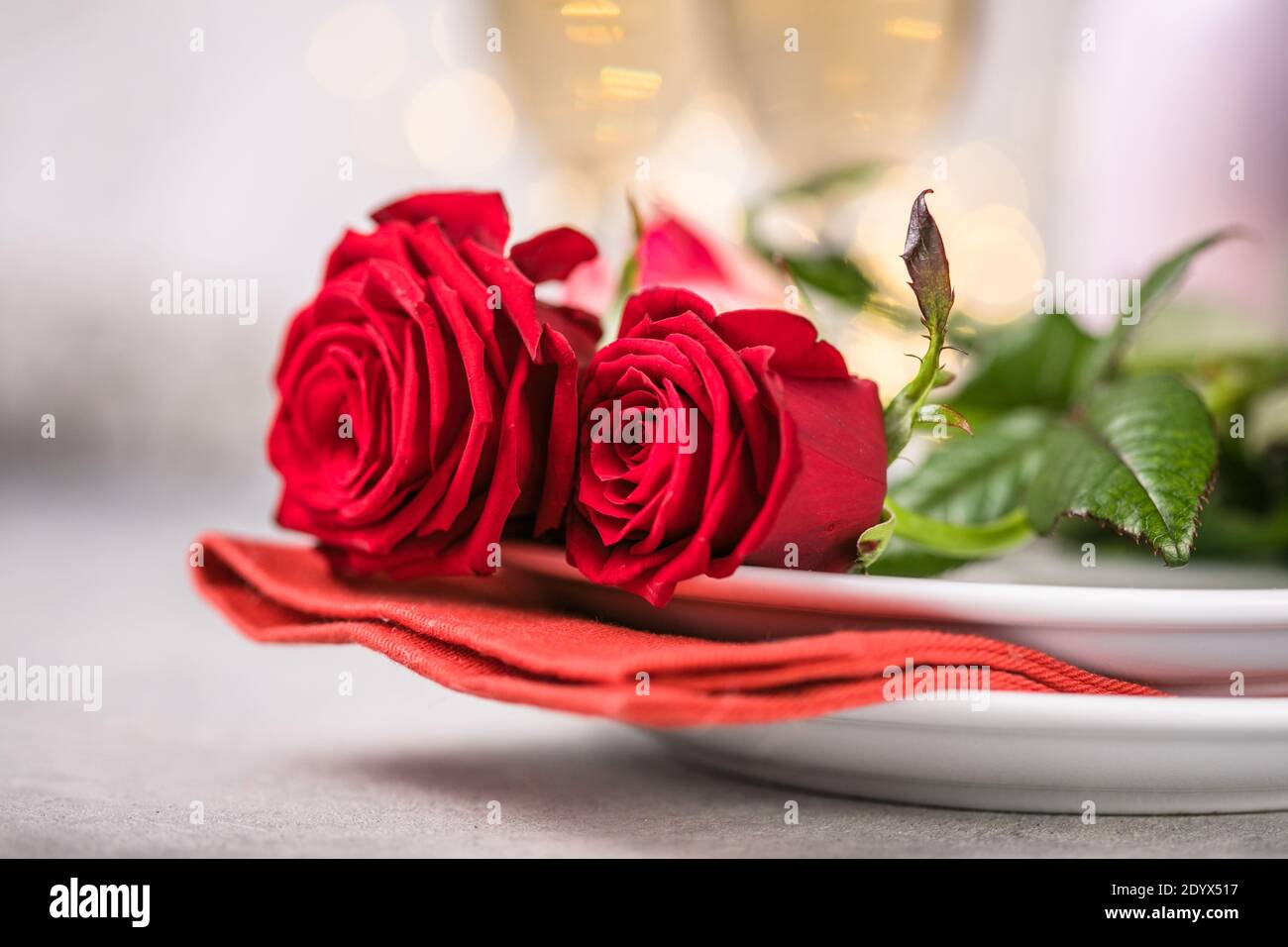 Valentines day table setting red roses and champagne glasses on ...