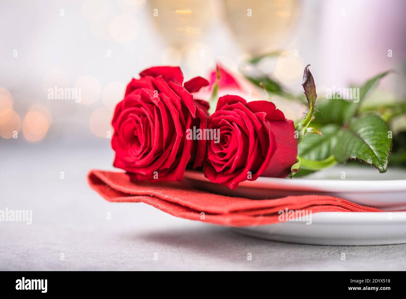 Valentines day table setting red roses and champagne glasses on ...