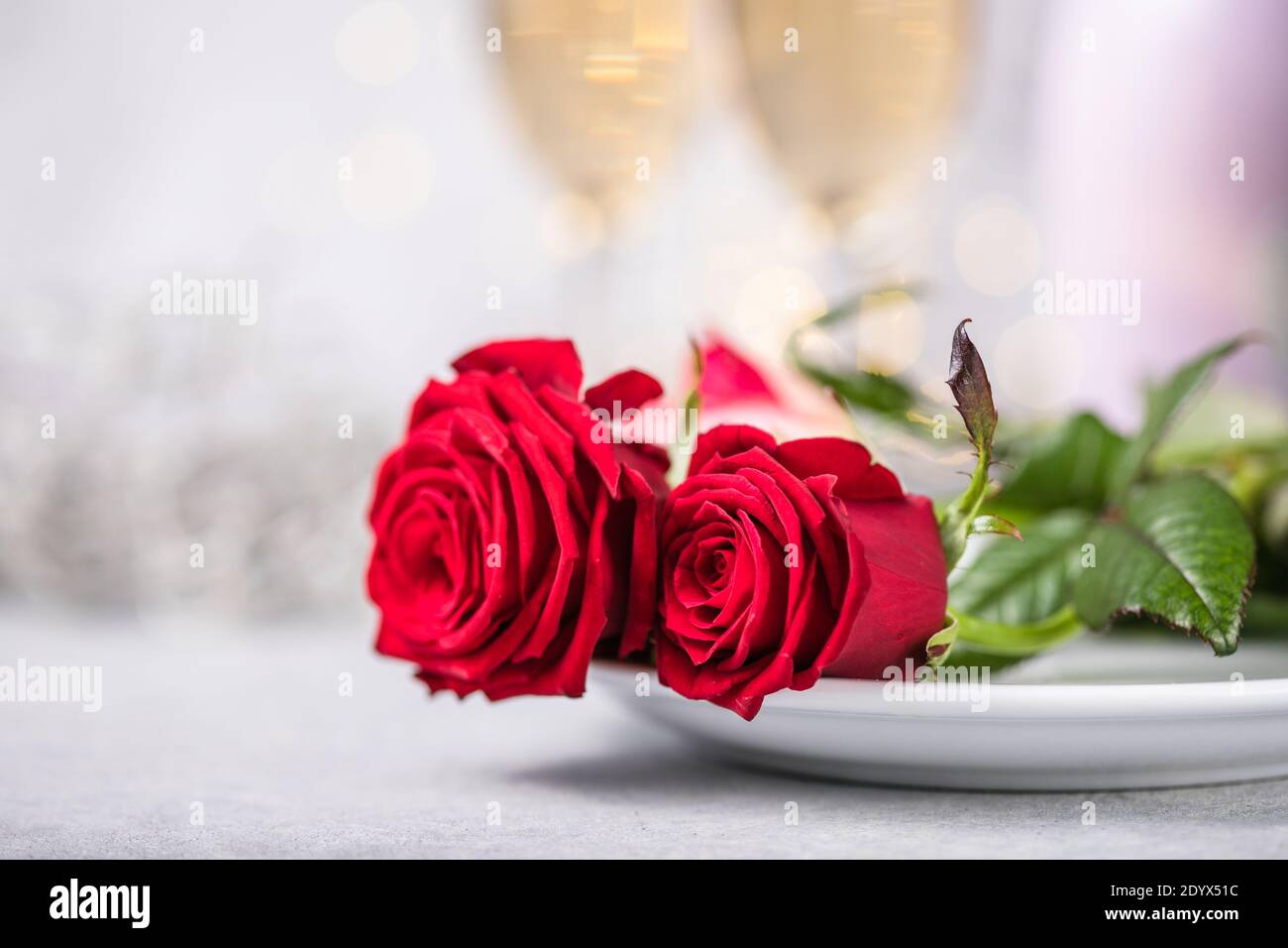 Valentines day table setting red roses and champagne glasses on ...