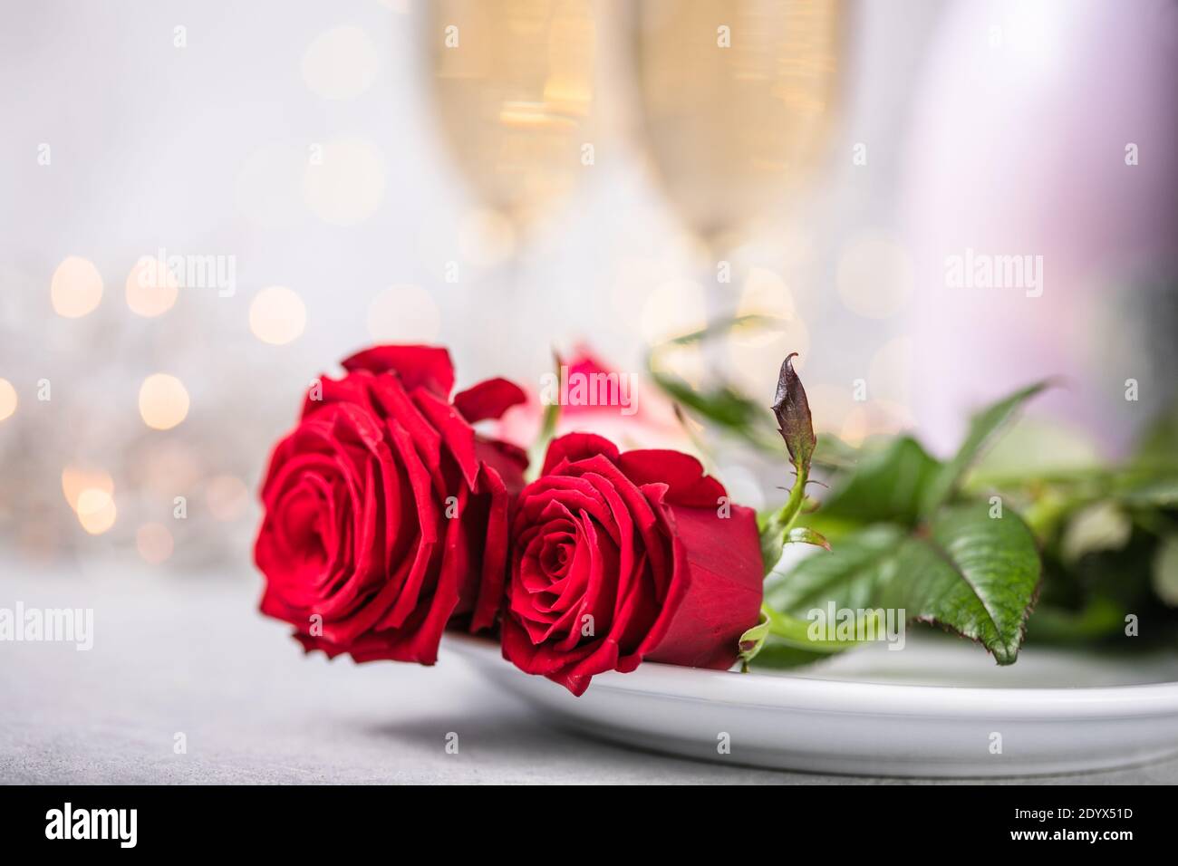 Valentines day table setting red roses and champagne glasses on ...