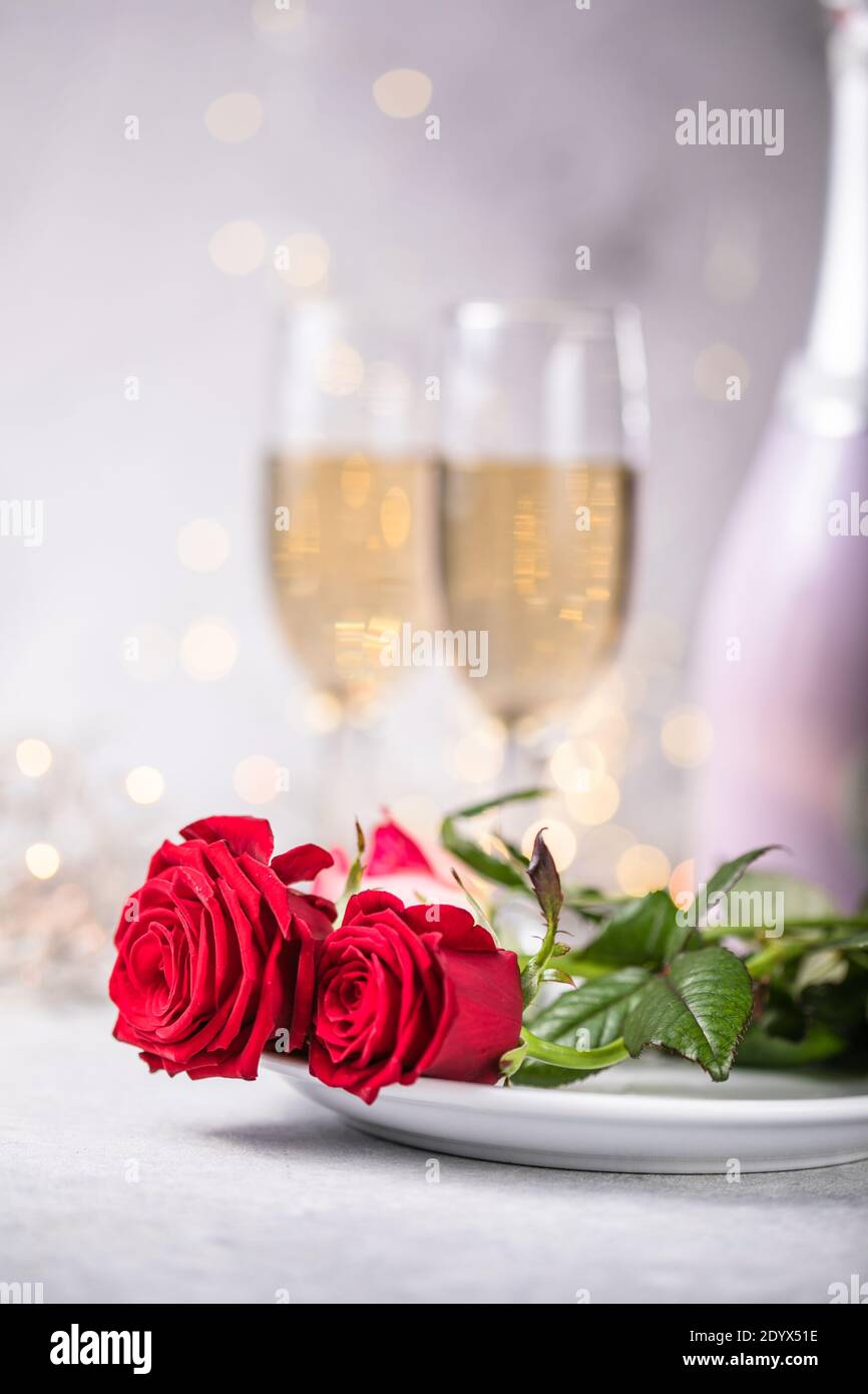 Valentines day table setting red roses and champagne glasses on ...
