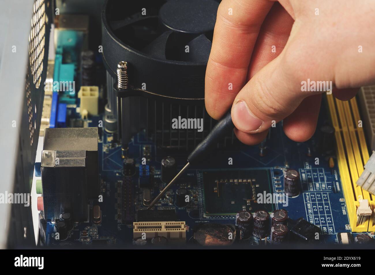 Close-up on the hands with screwdriver tool of the technician repairing a PC computer. Stock Photo