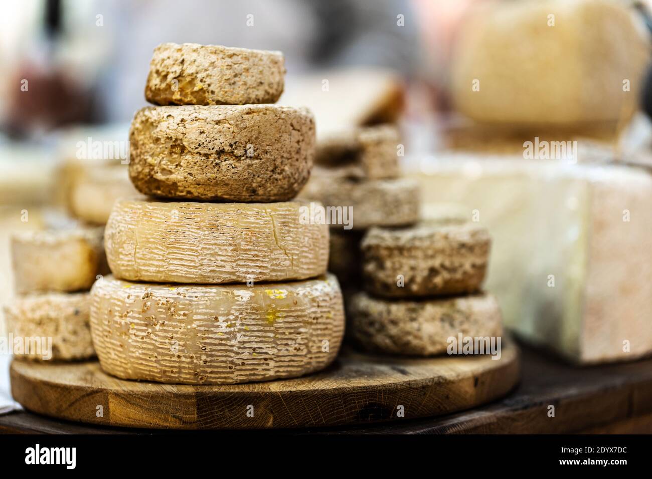 Goat cheese heads stacked on wooden plate Stock Photo Alamy