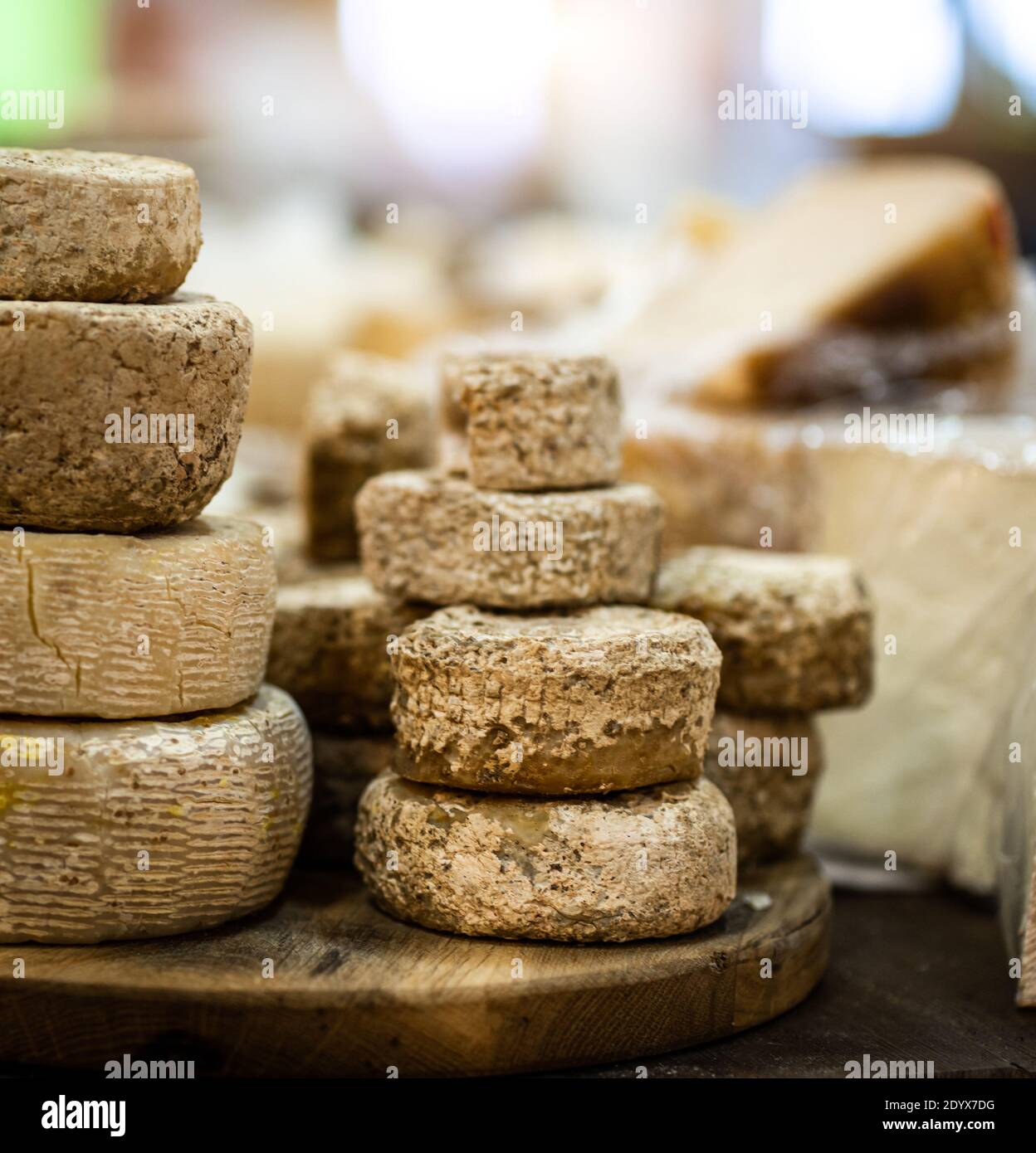 Goat cheese heads stacked on wooden plate Stock Photo Alamy
